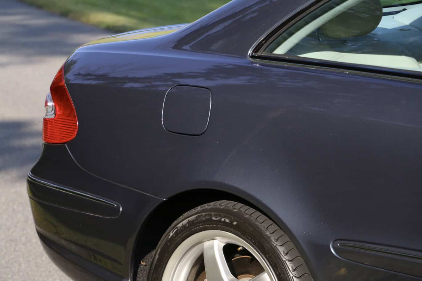 1999 Mercedes CLK500 — Rear view of a dark-colored classic car with a focus on the tail light and wheel.