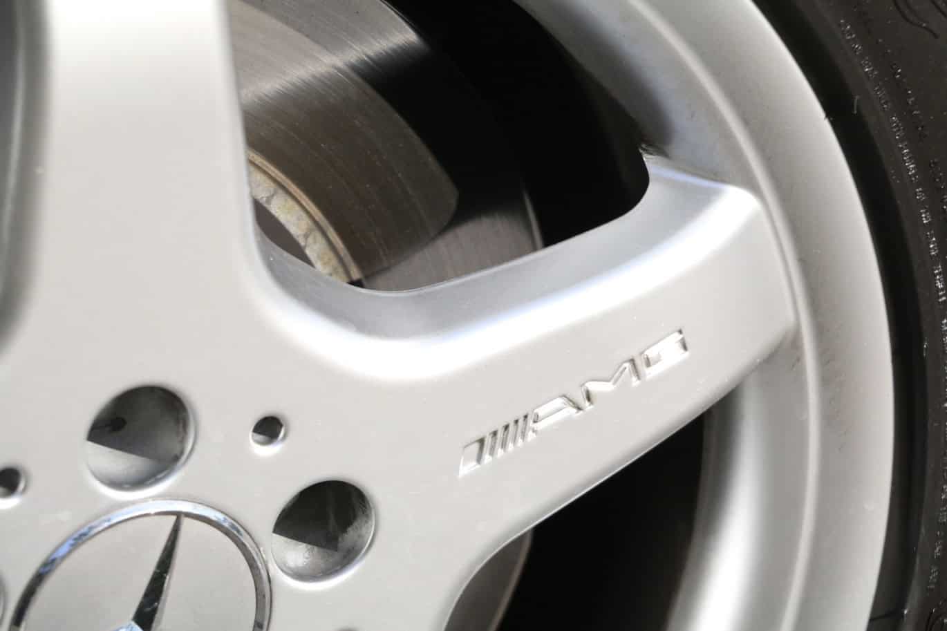 1999 Mercedes CLK500 — Close-up of alloy wheel with AMG logo on a classic car.
