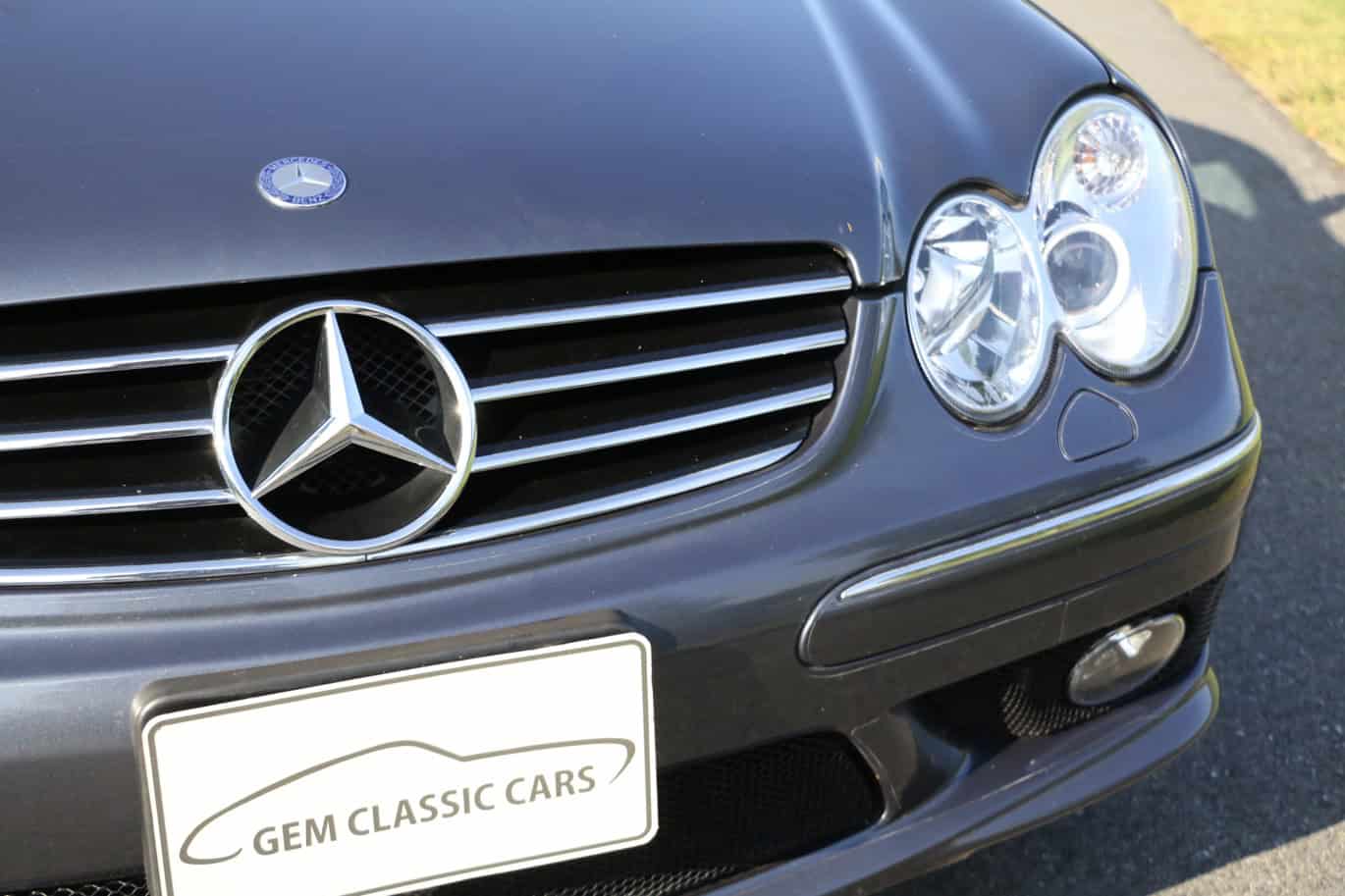 1999 Mercedes CLK500 — Close-up of classic car front with grille, headlights, and emblem.