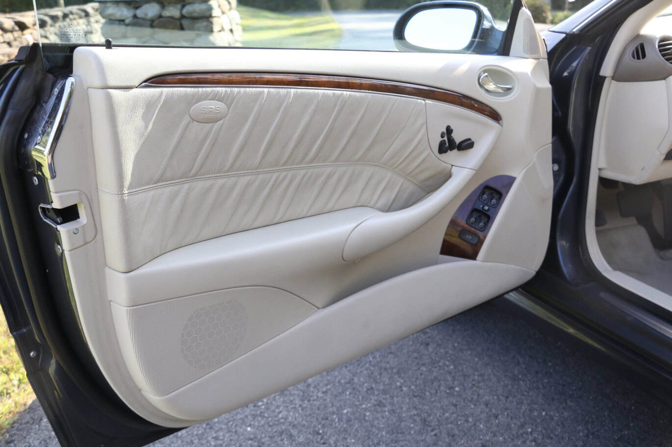 1999 Mercedes CLK500 — Close-up of classic car interior door with leather and wood trim.