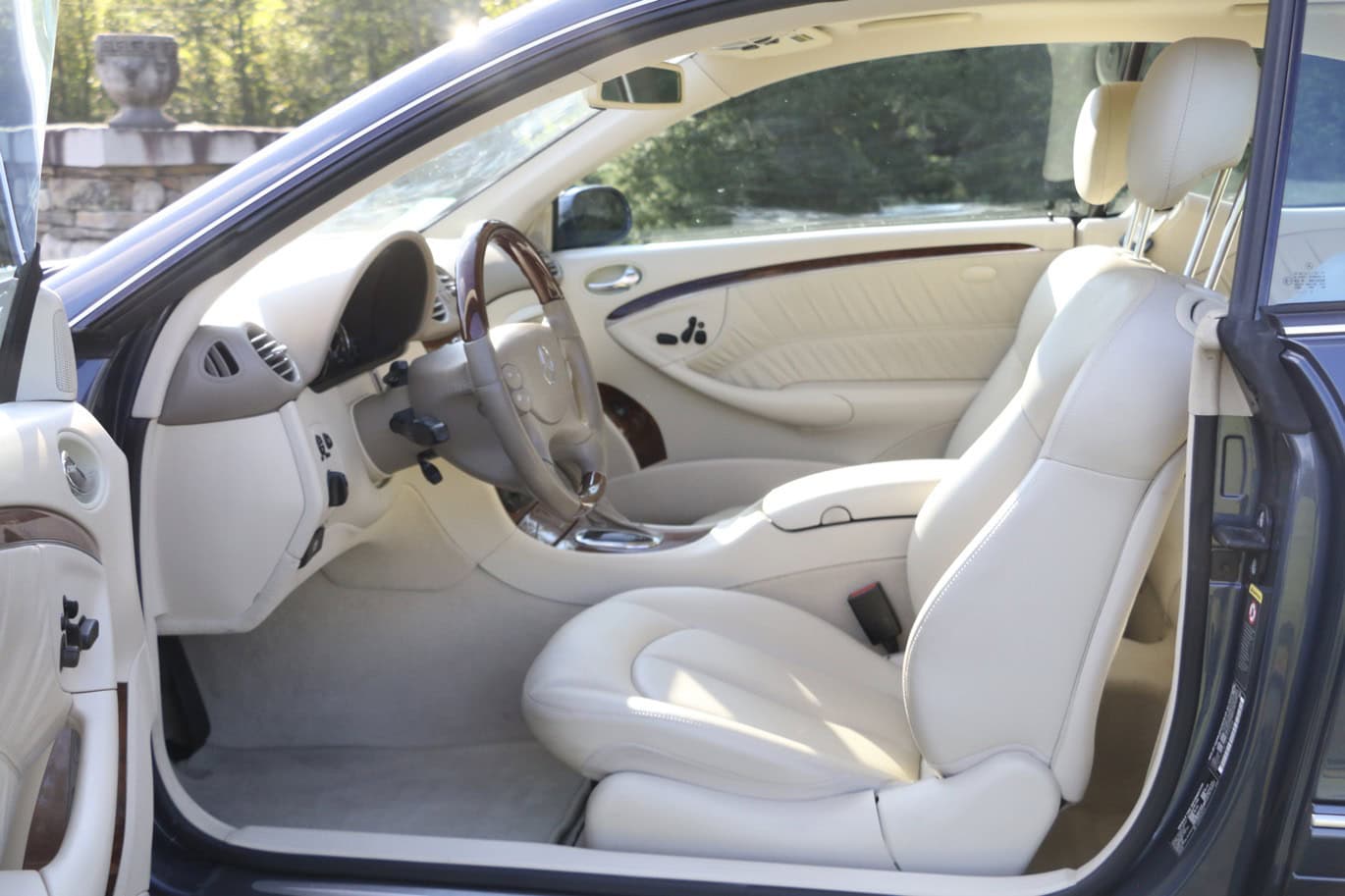 1999 Mercedes CLK500 — Interior shot of a classic car with white leather seats and dashboard.