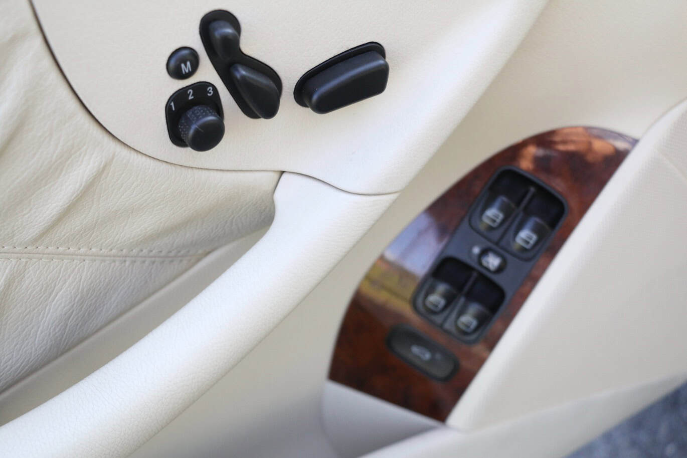 1999 Mercedes CLK500 — Close-up of classic car interior door with window and lock controls.