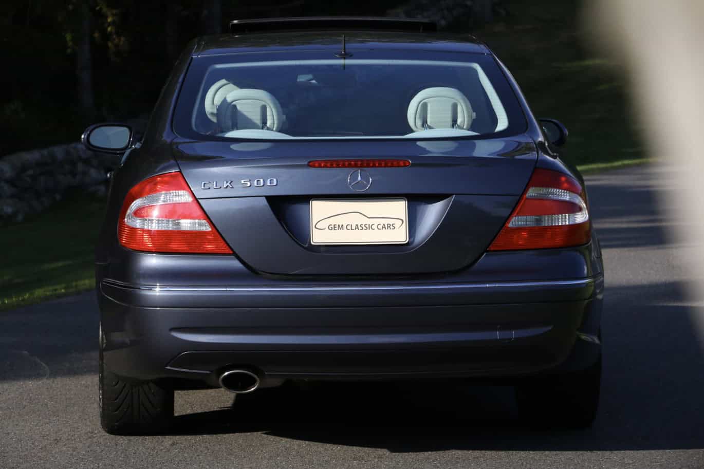 1999 Mercedes CLK500 — Rear view of a black classic car on the street.