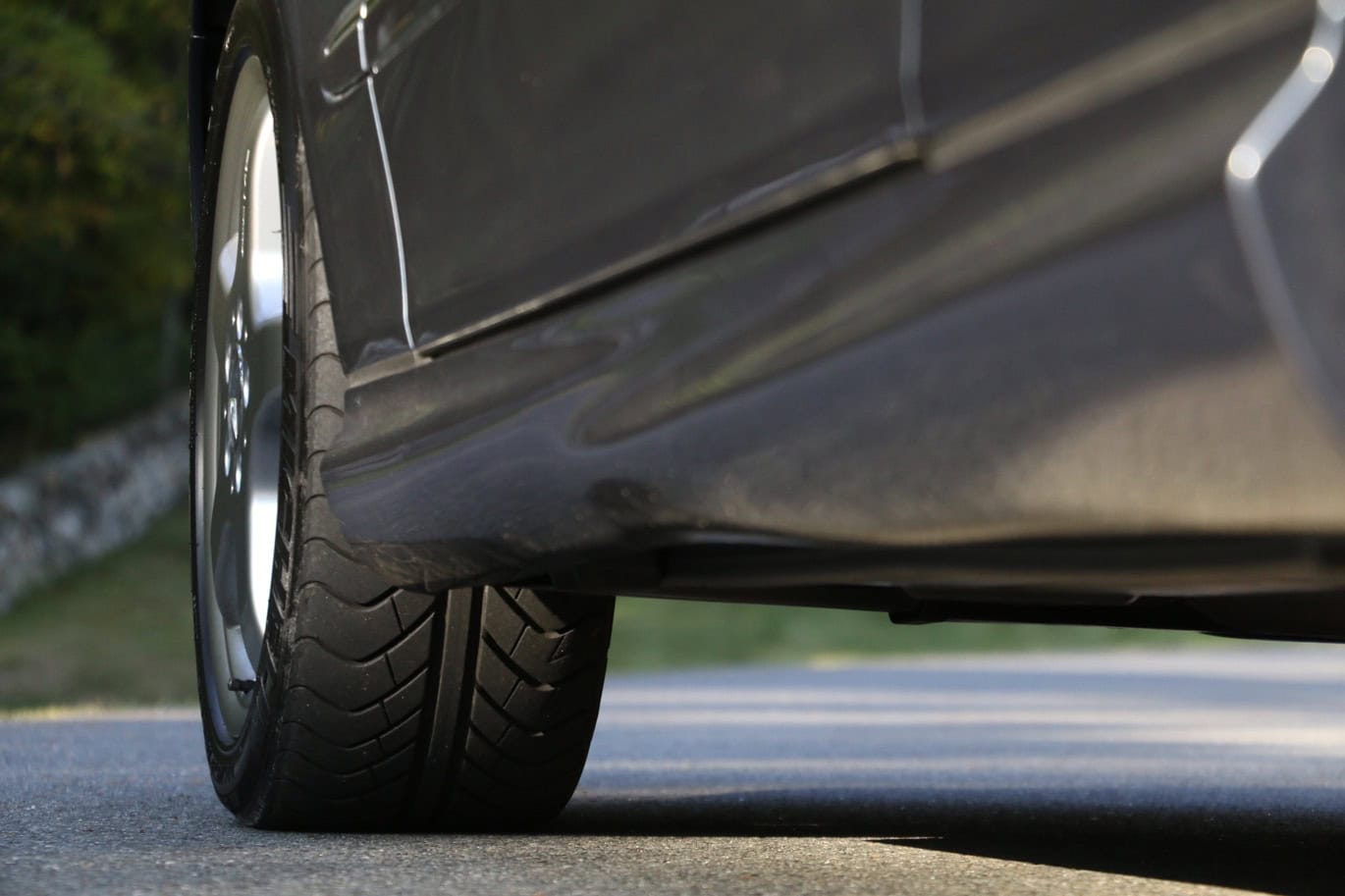 1999 Mercedes CLK500 — Close-up of a classic car's front wheel and body side.