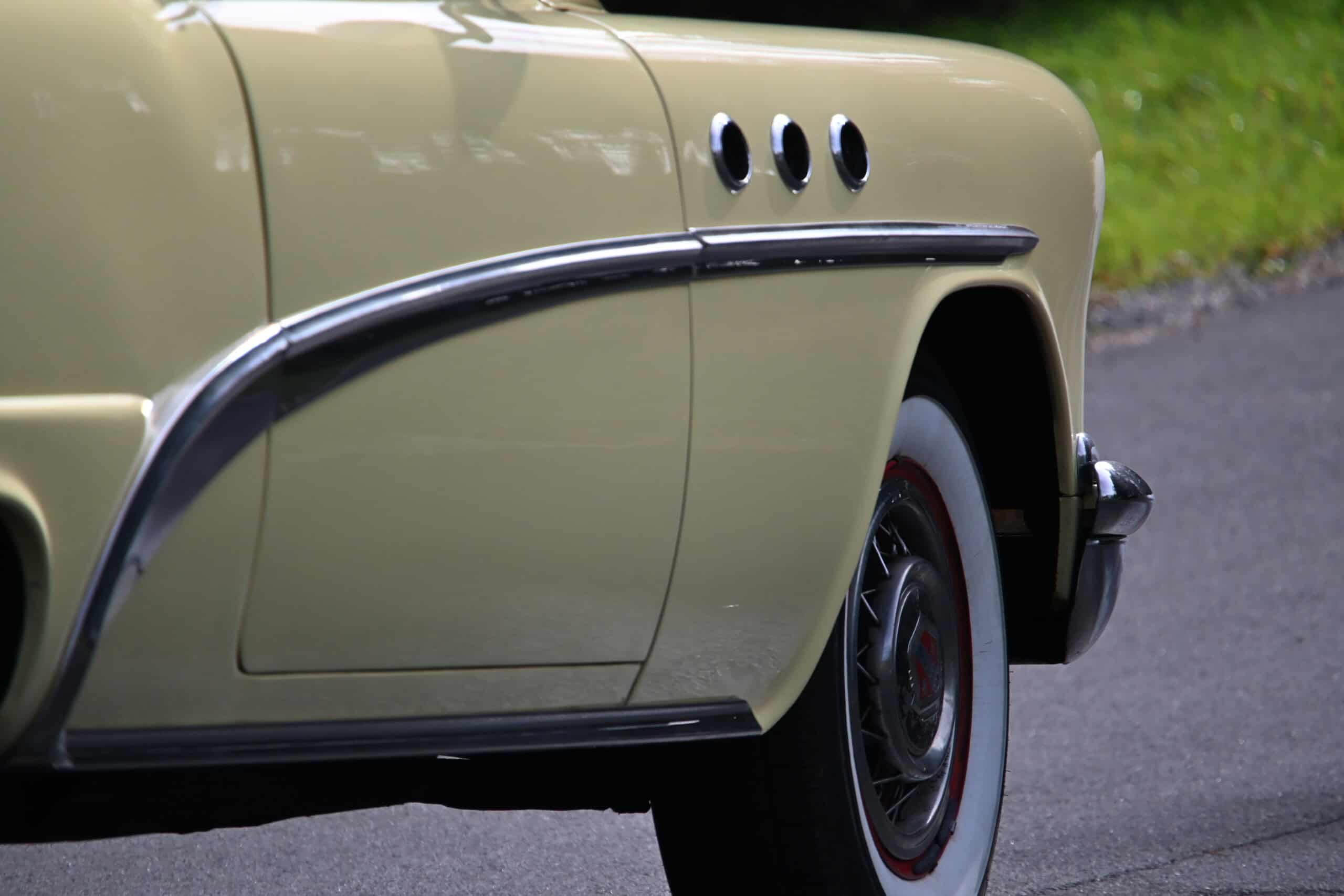 1953 Buick special — Close-up of classic car side with unique body features and wheel.