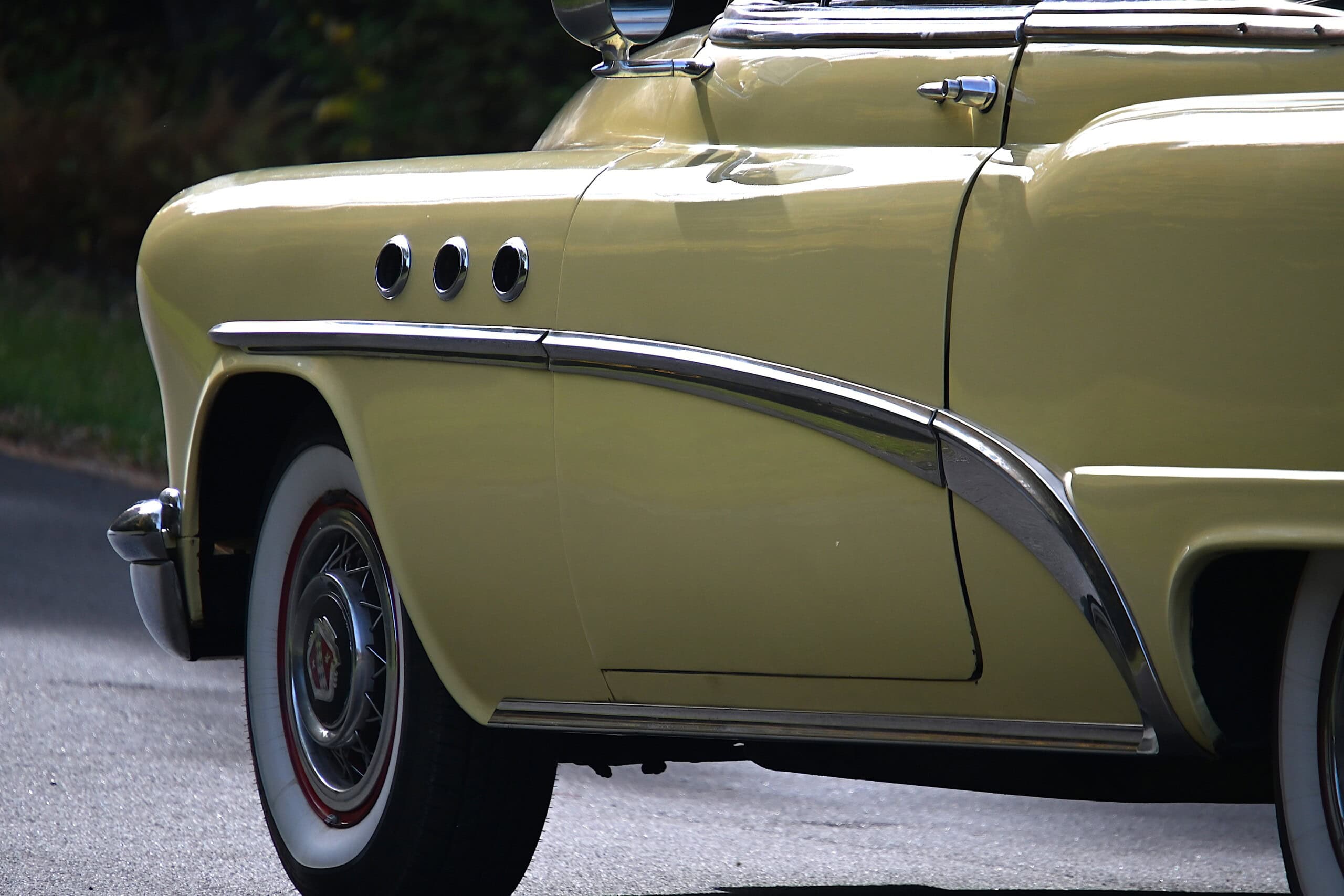 1953 Buick special — Close-up of classic car body with chrome trim and yellow paint.