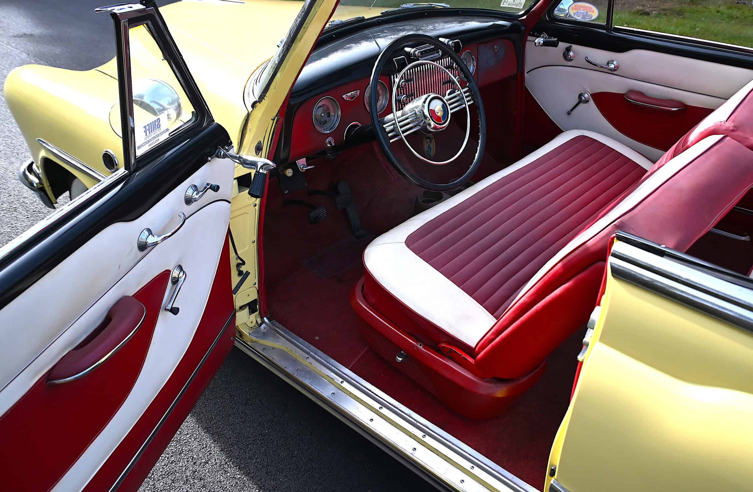 1953 Buick special — Interior shot of a classic car with red and white seats and dashboard.