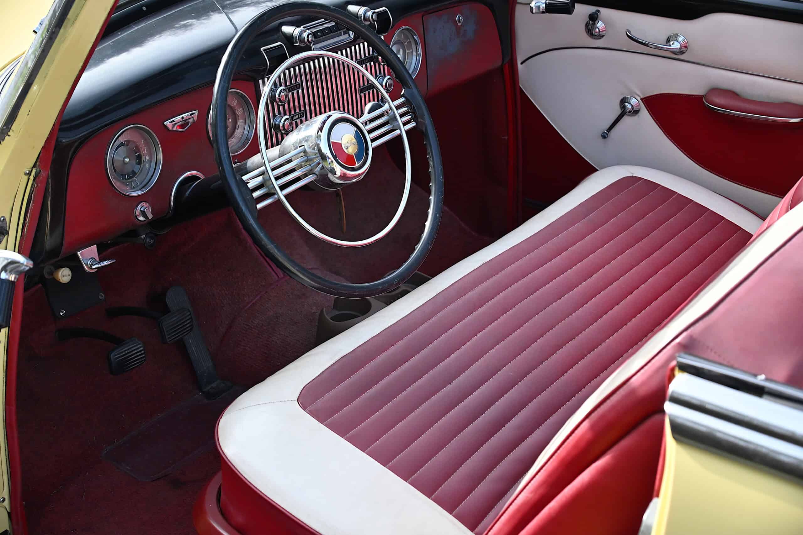 1953 Buick special — Interior shot of a classic car with red and white seats and dashboard.