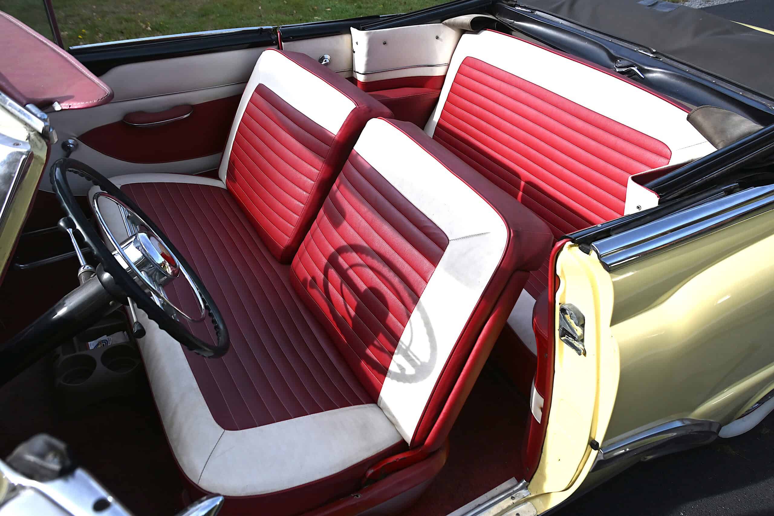 1953 Buick special — Interior shot of a classic car with red and white bench seats.