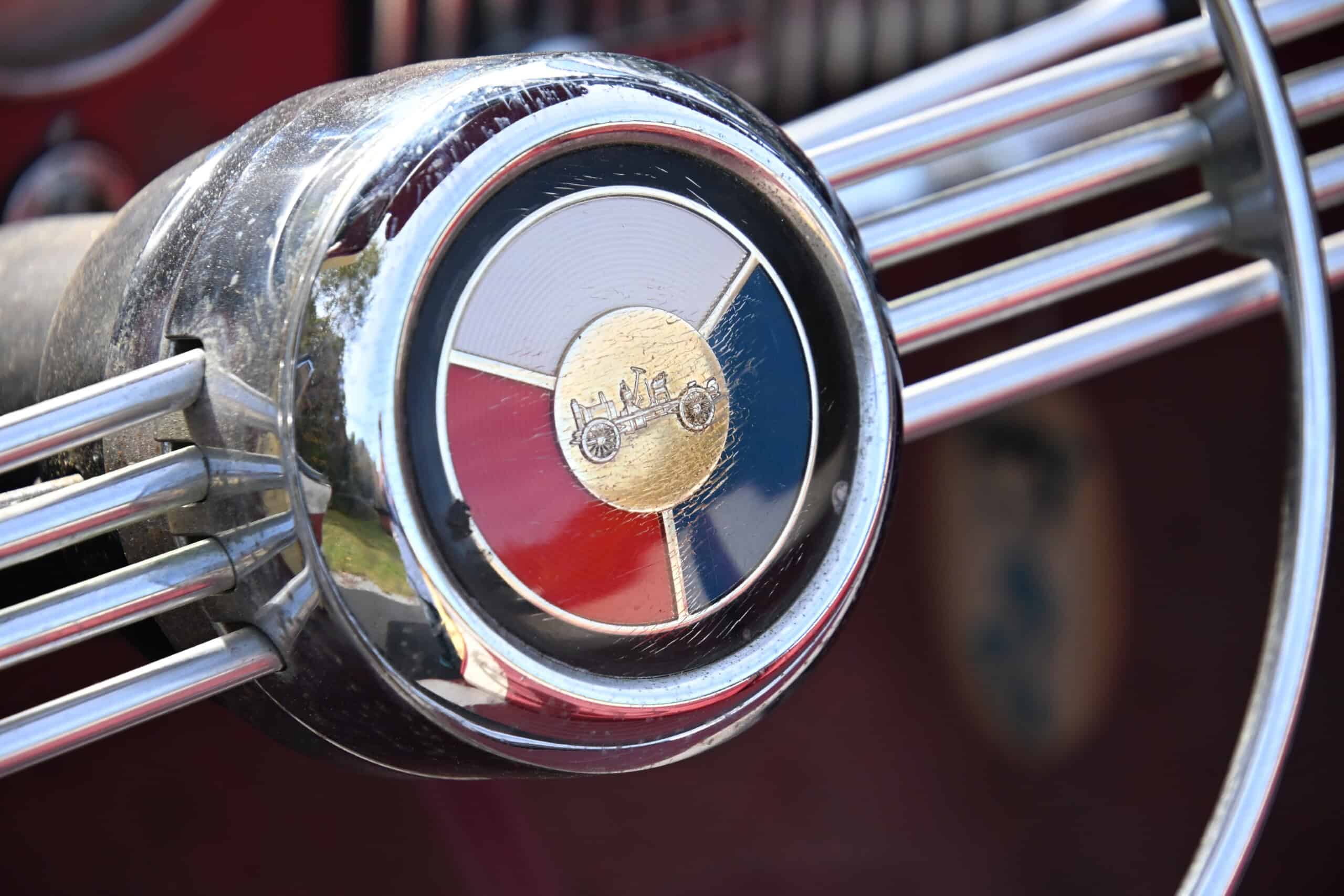 1953 Buick special — Close-up of a classic car steering wheel with a vintage emblem.