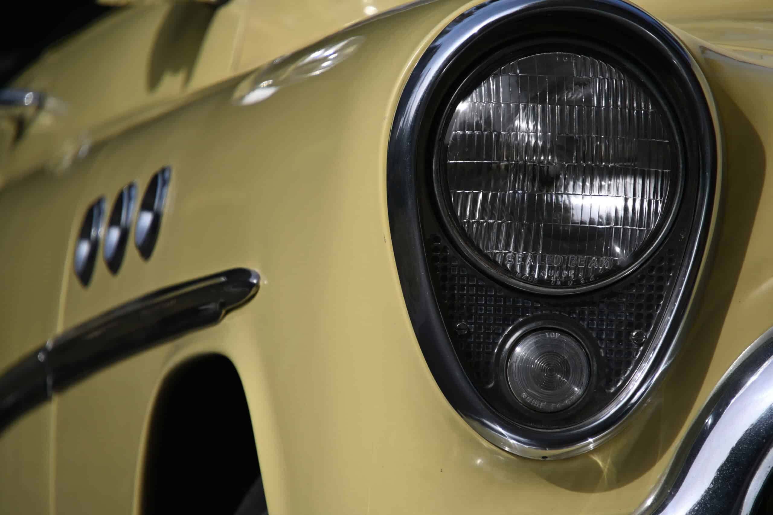 1953 Buick special — Close-up of classic car headlight and front body in yellow.