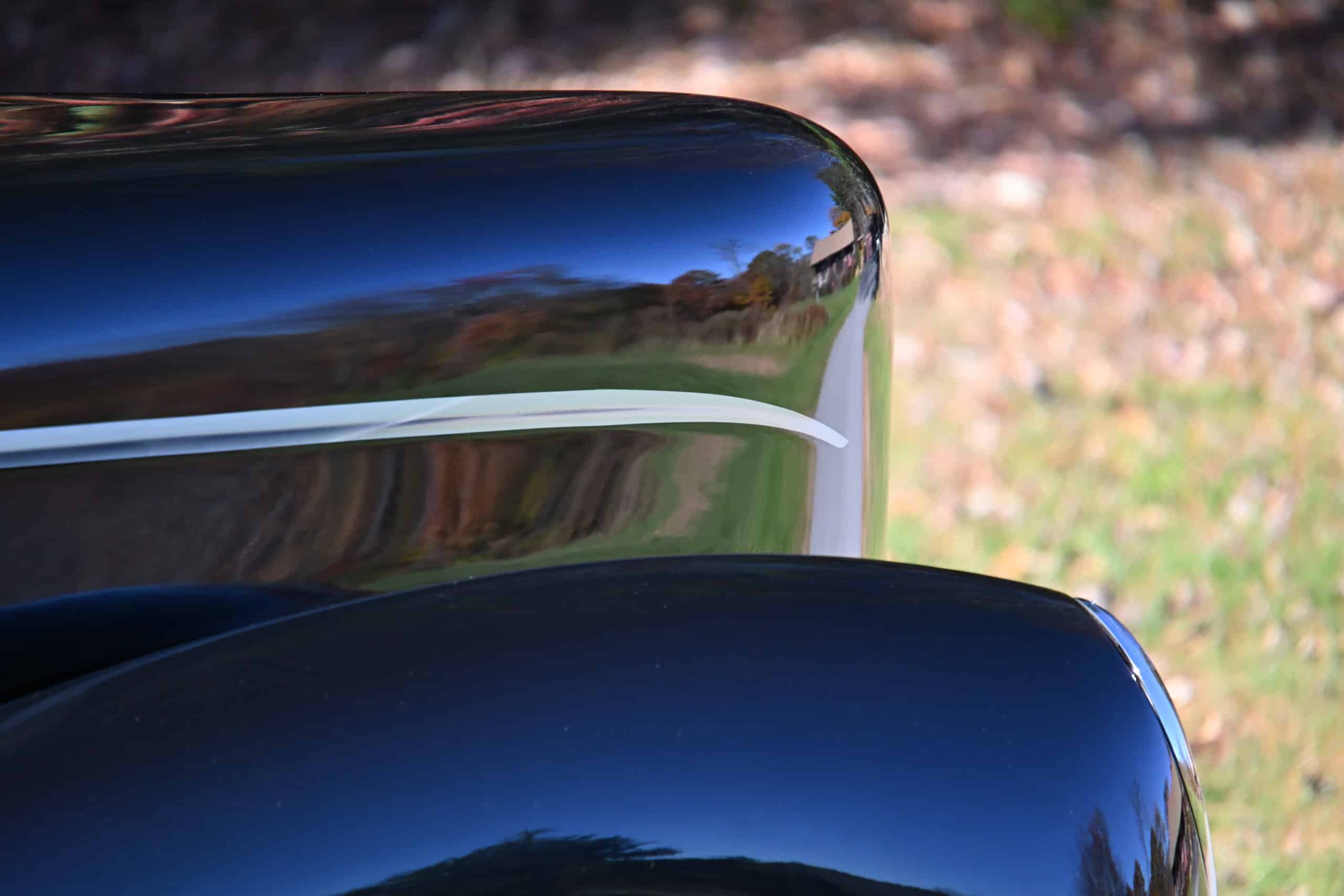 1941 Willys Custom Street Rod — Close-up of a black classic car's exterior with reflection.
