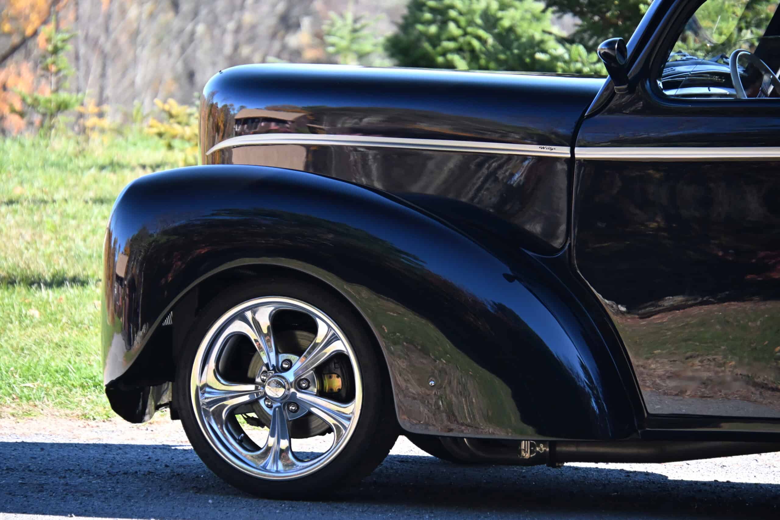 1941 Willys Custom Street Rod — Close-up of classic car wheel and fender with shiny chrome rim.