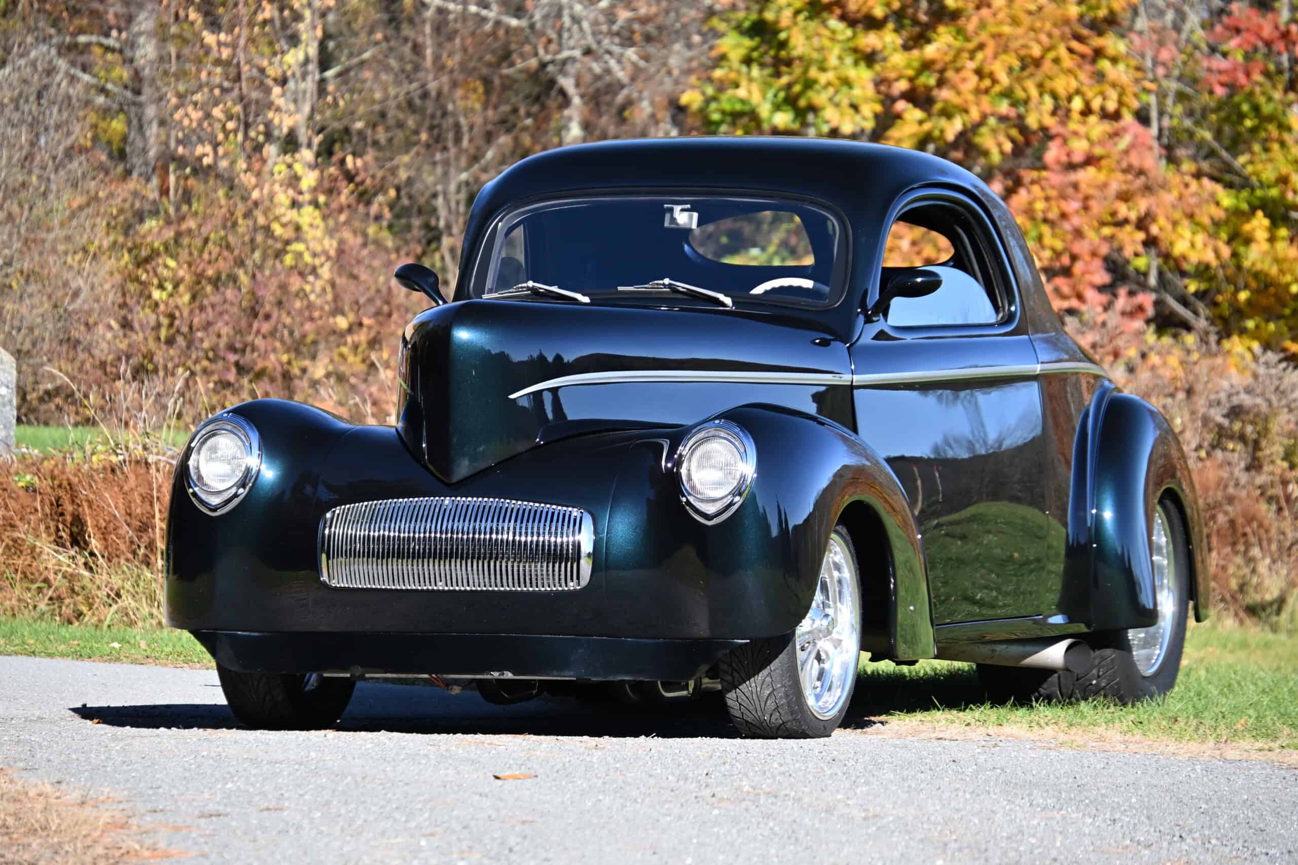1941 Willys Custom Street Rod — Black classic car parked outdoors with autumn trees in background.