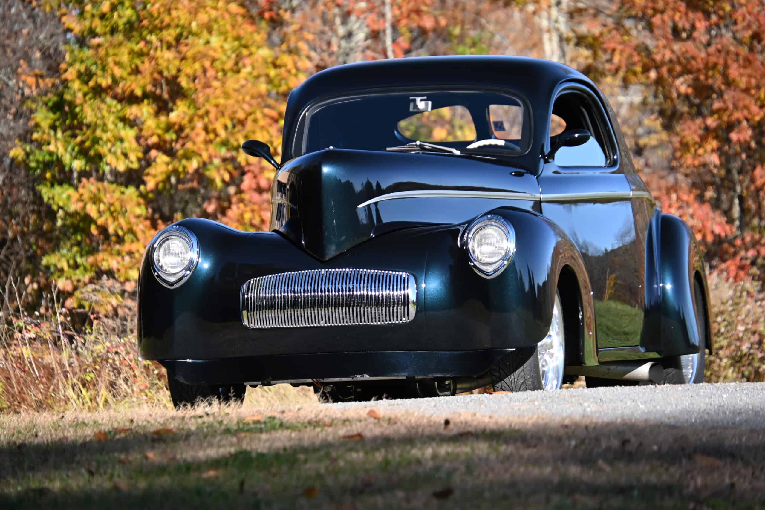 1941 Willys Custom Street Rod — Black classic car with rounded body and chrome grille in fall scenery.