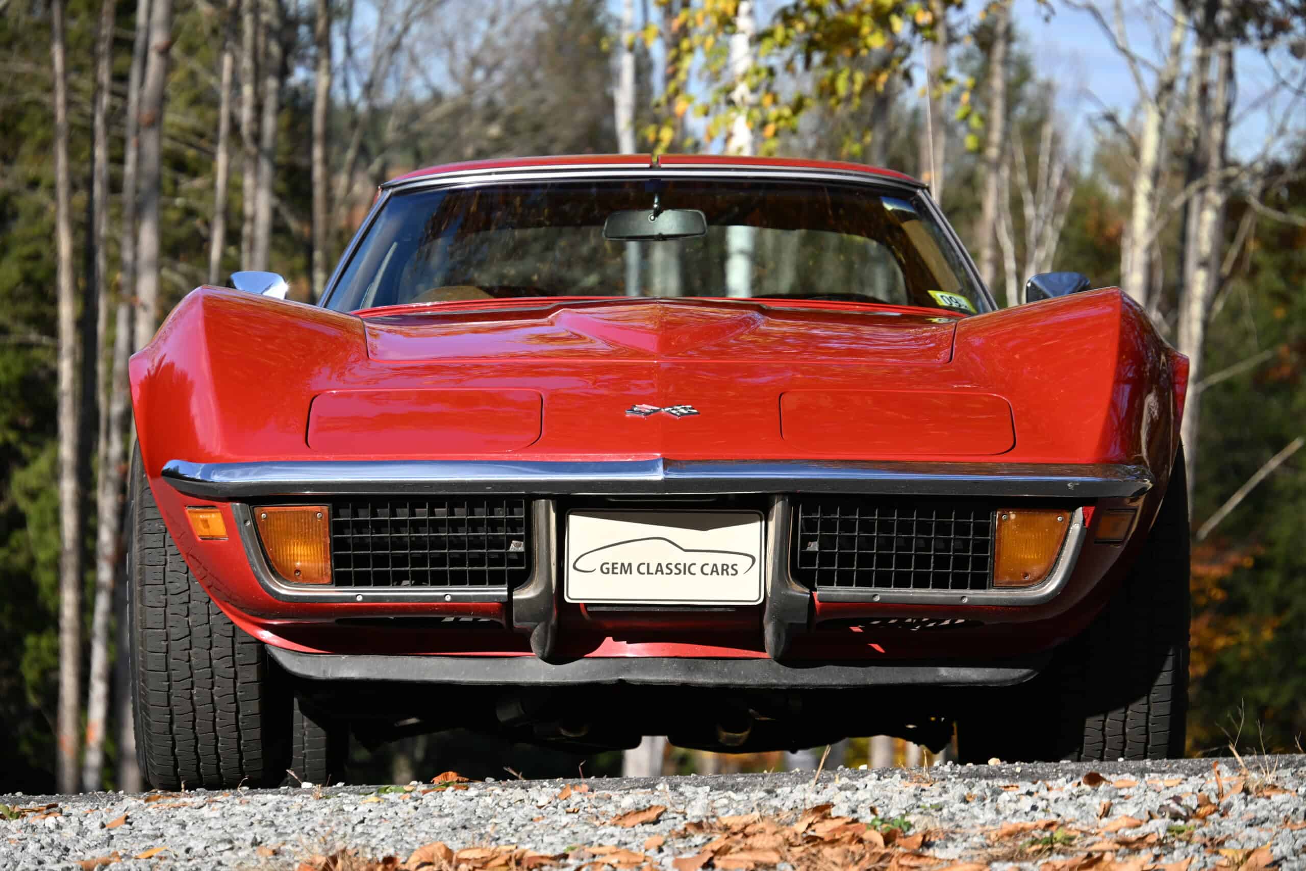 1972 Chevrolet corvette — Red classic car with sleek body and low stance on gravel.