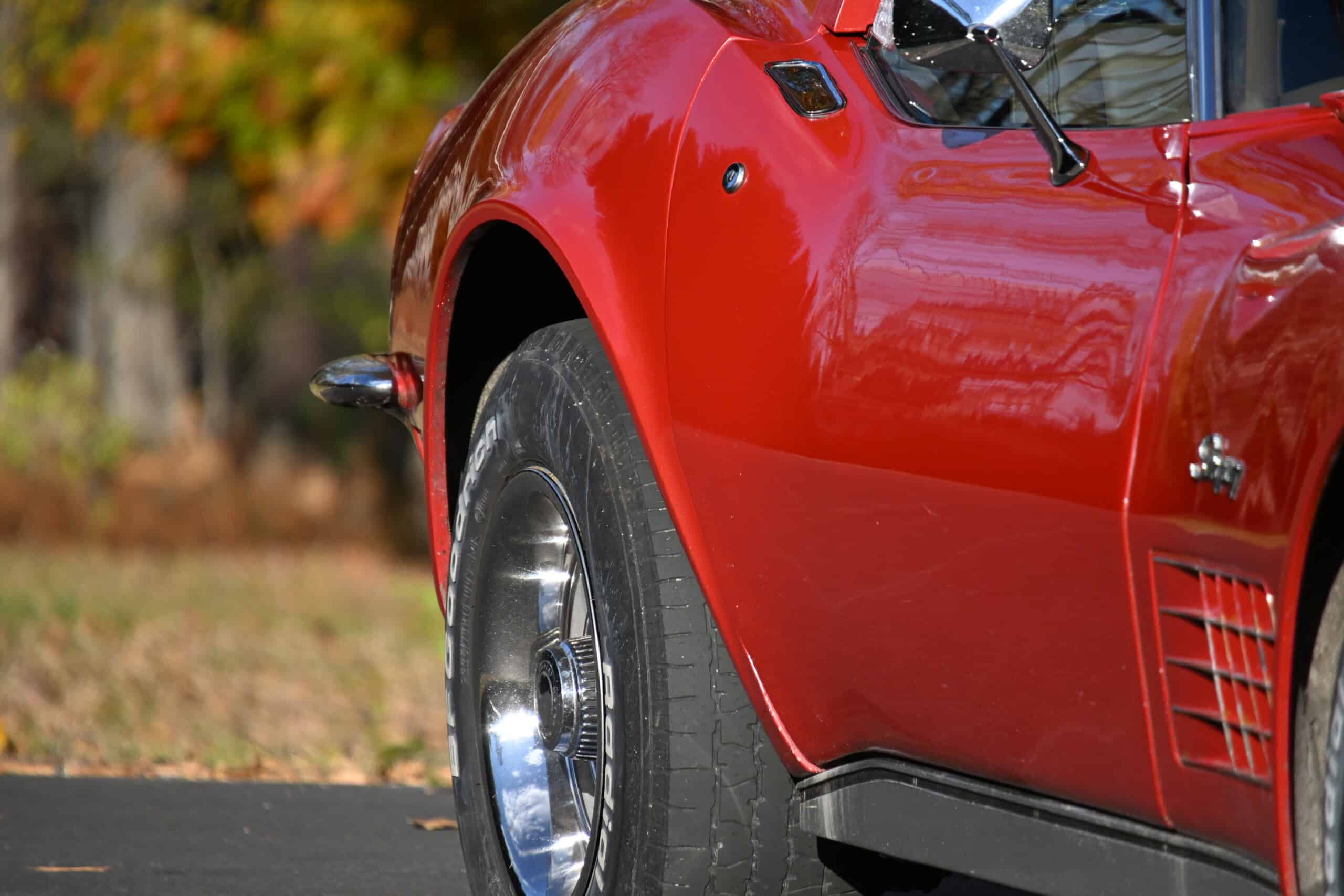 1972 Chevrolet corvette — Close-up of a red classic car's front wheel and body.