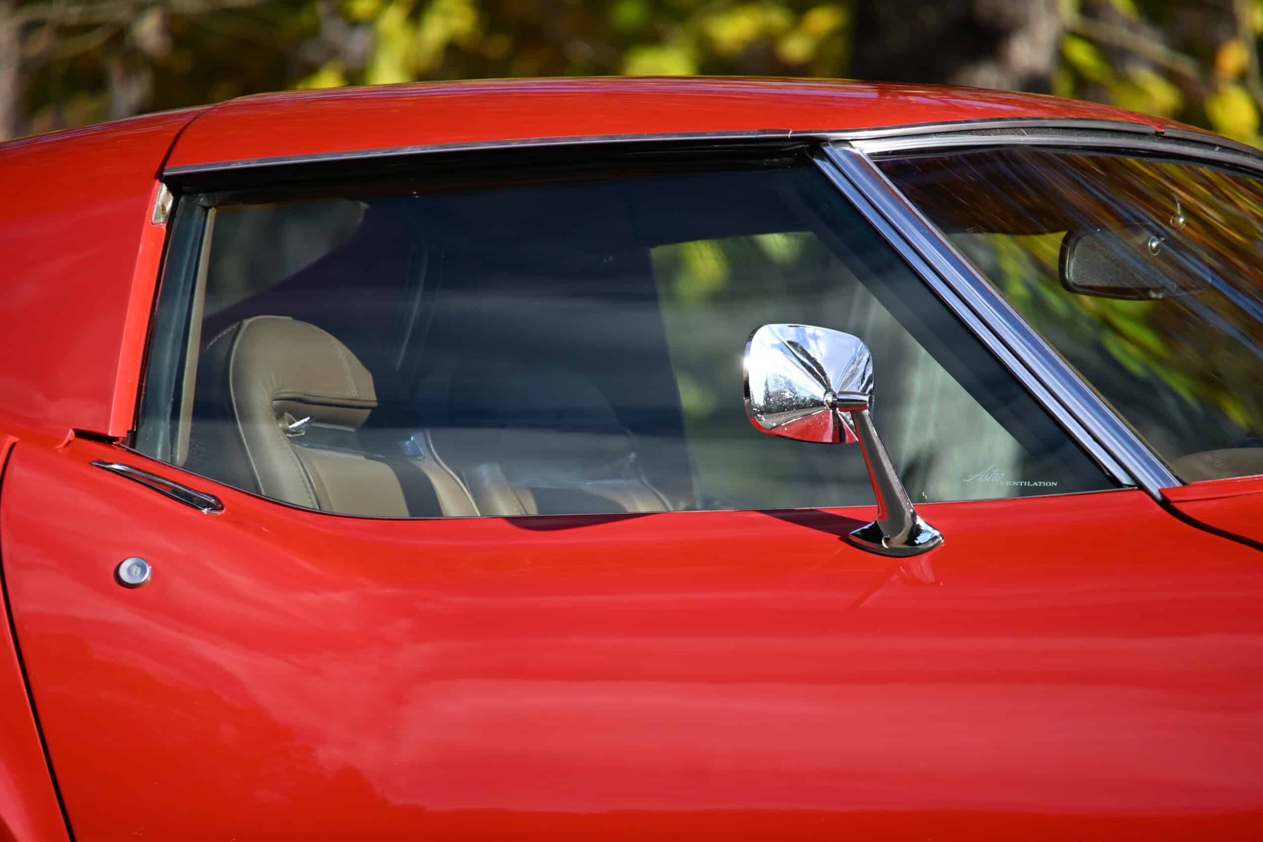 1972 Chevrolet corvette — Close-up of classic car with red body and side mirror.