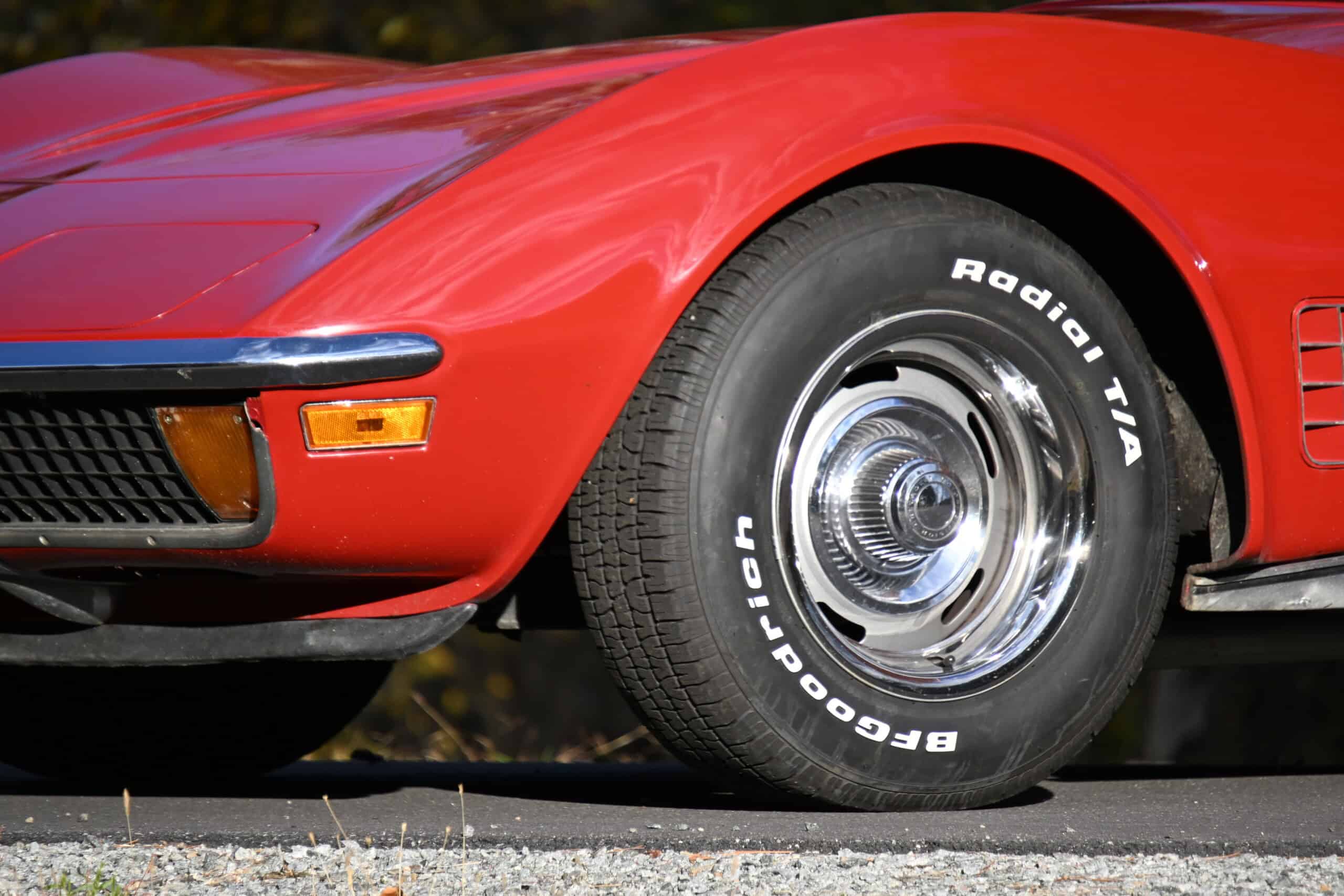 1972 Chevrolet corvette — Close-up of classic car with red exterior and chrome wheel.