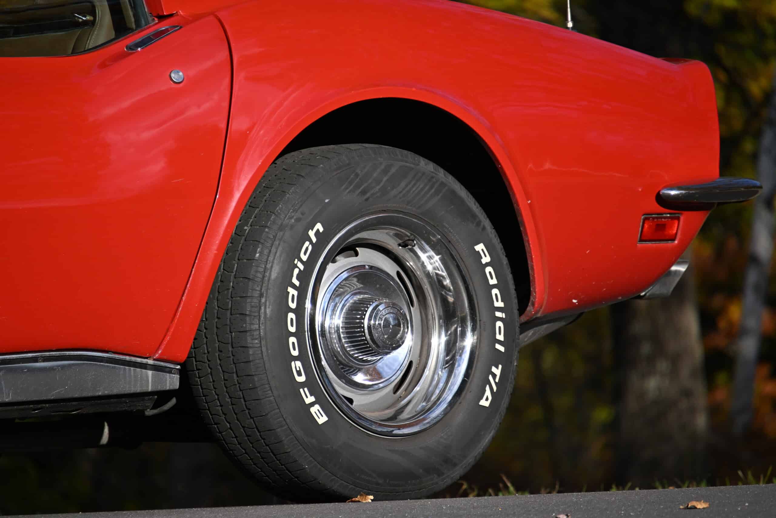 1972 Chevrolet corvette — Close-up of a classic car's front wheel and red body.