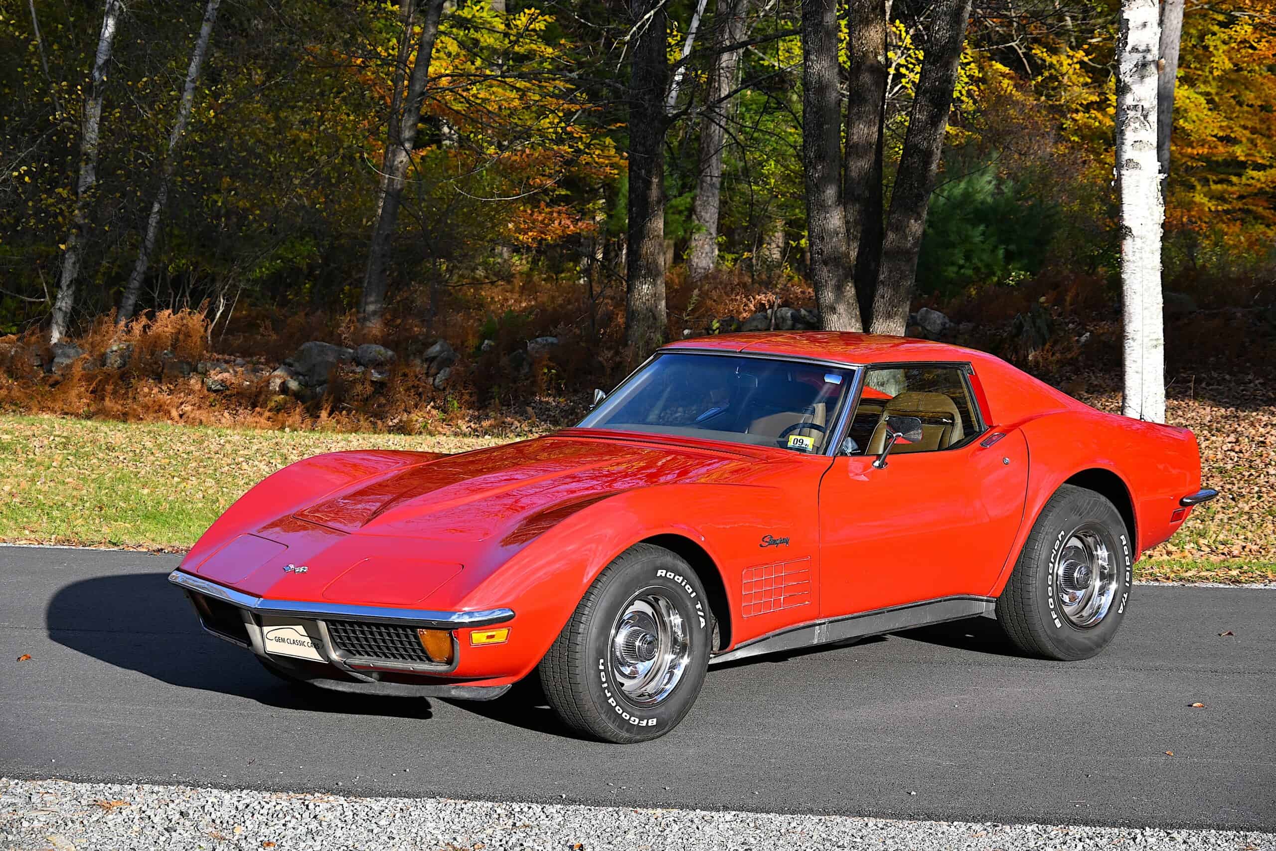 1972 Chevrolet corvette — Red classic car with sleek body and chrome wheels on road.