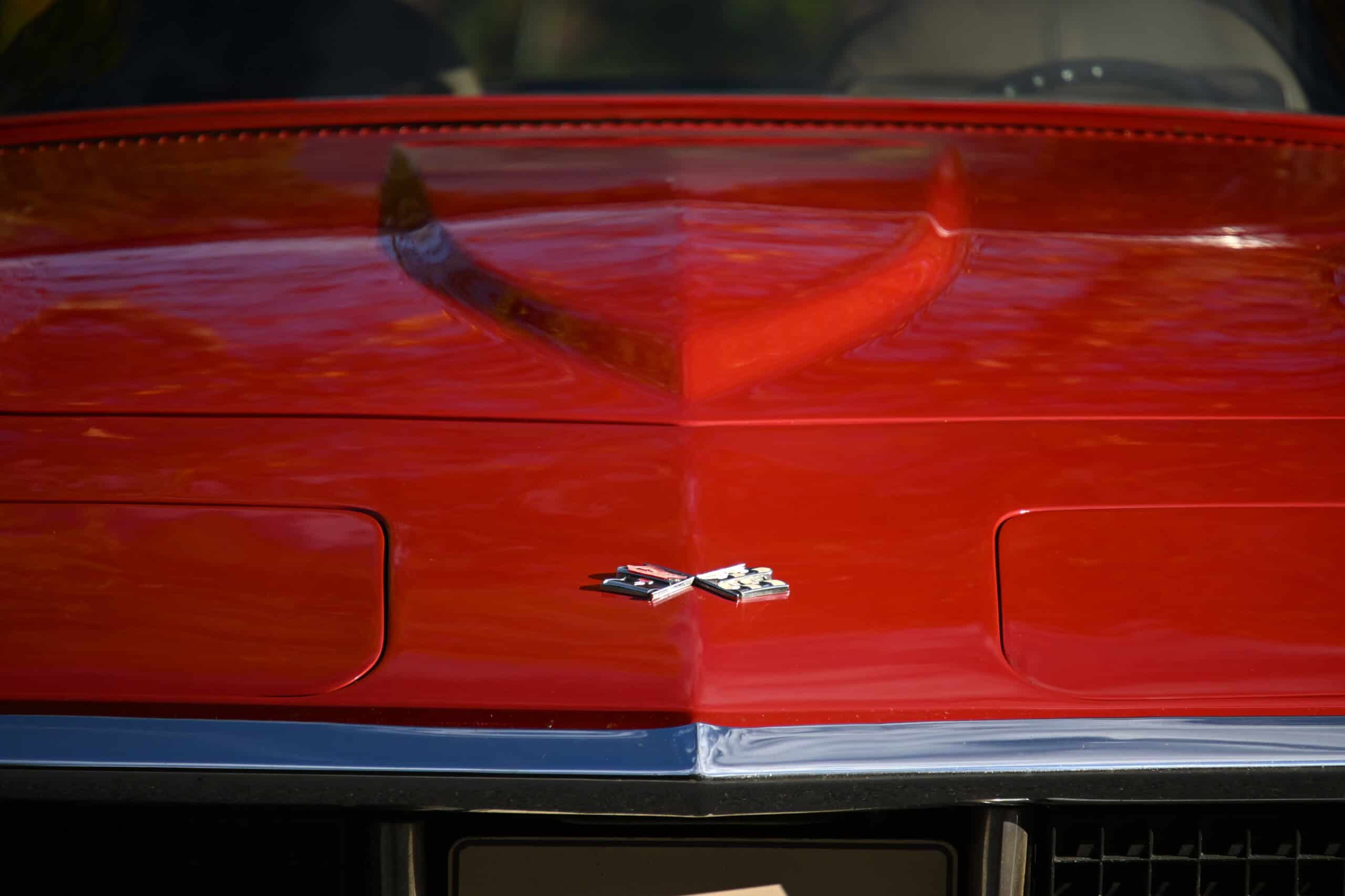 1972 Chevrolet corvette — Close-up of classic car hood with emblem and red paint.