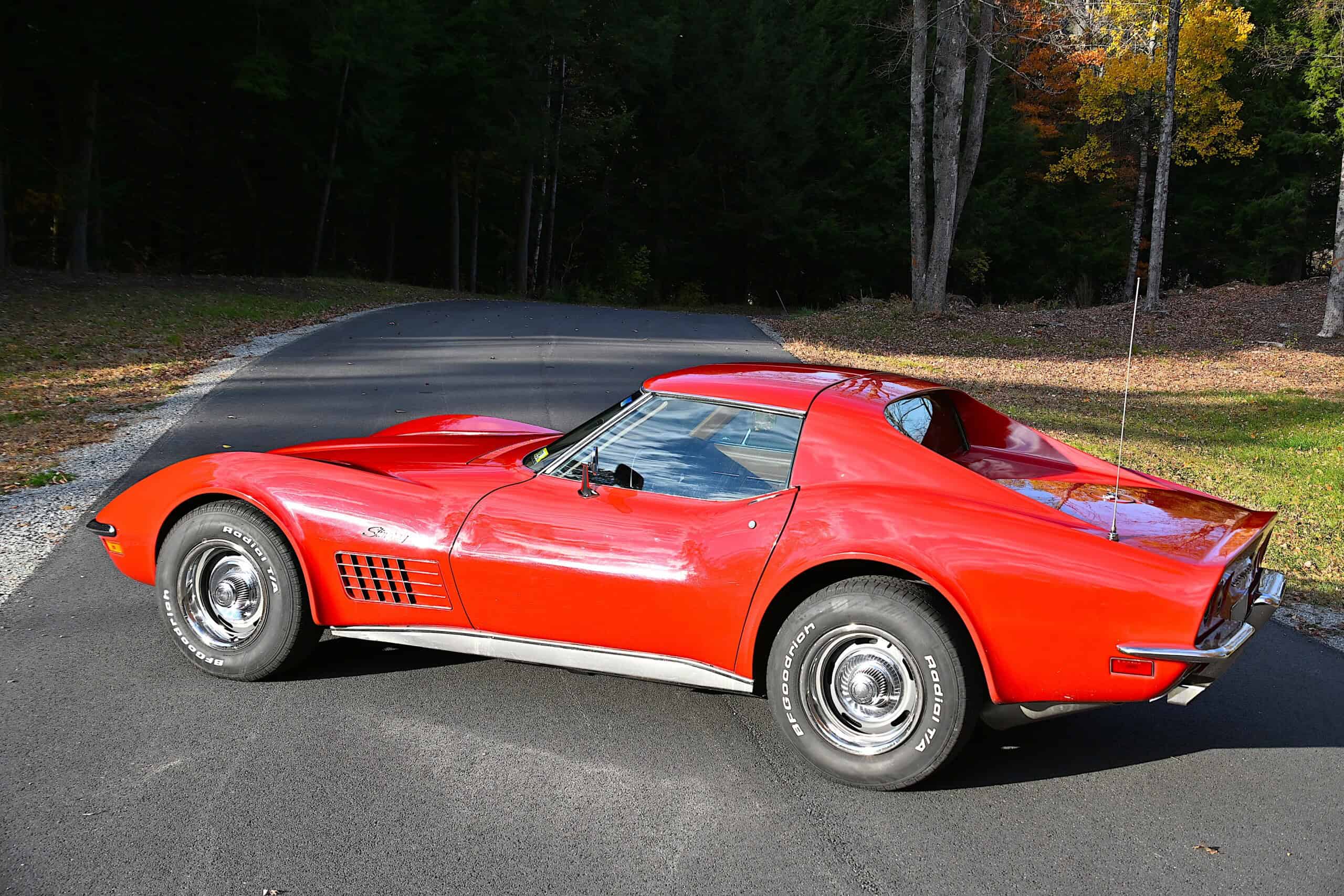1972 Chevrolet corvette — Red classic car with sleek body and chrome wheels on road.