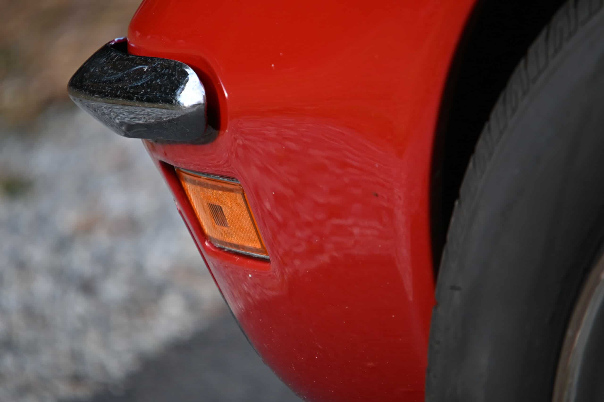 1972 Chevrolet corvette — Close-up of red classic car front bumper and tire.
