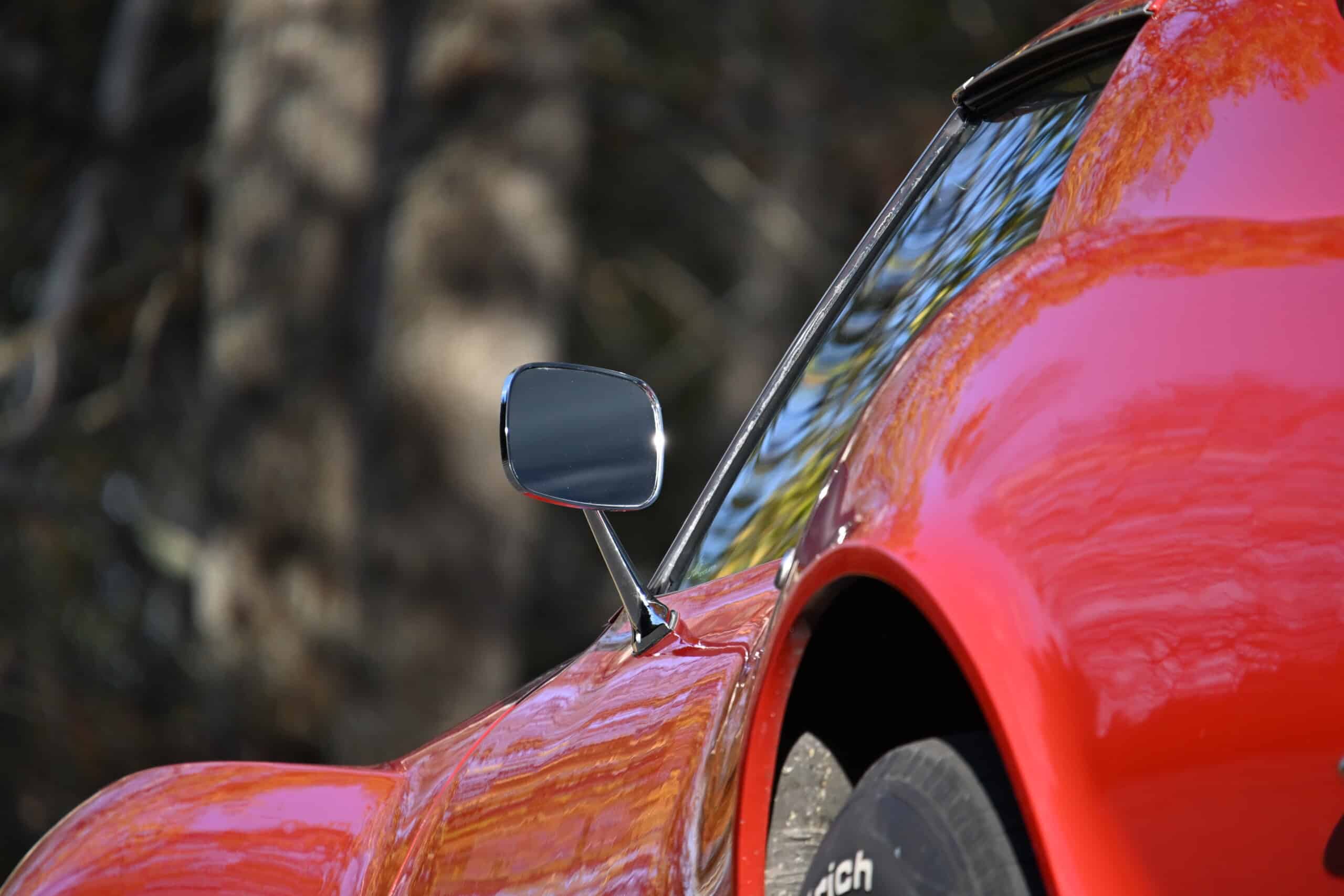 1972 Chevrolet corvette — Red classic car with side mirror and curved body.