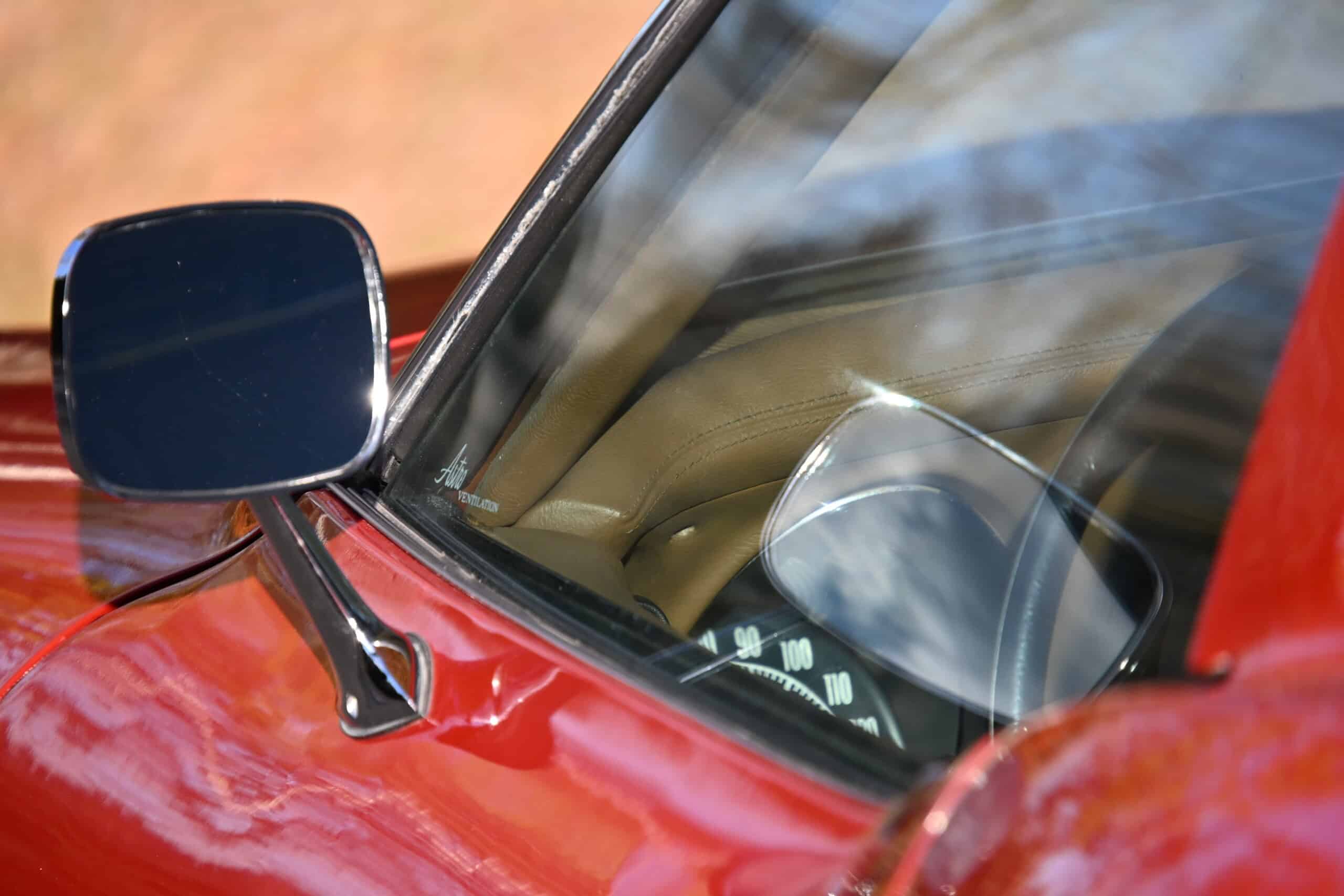 1972 Chevrolet corvette — Close-up of classic car interior and side mirror with red exterior.