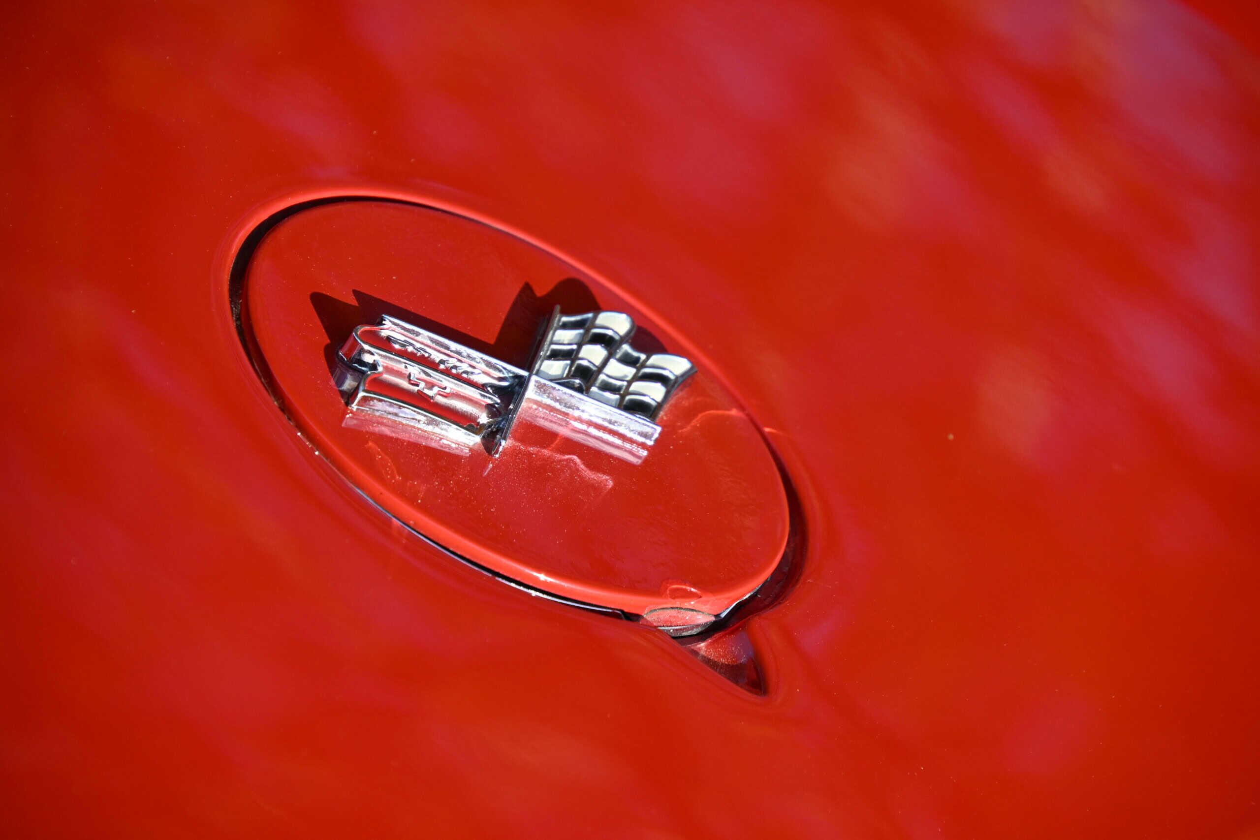 1972 Chevrolet corvette — Close-up of chrome hood ornament on red classic car.