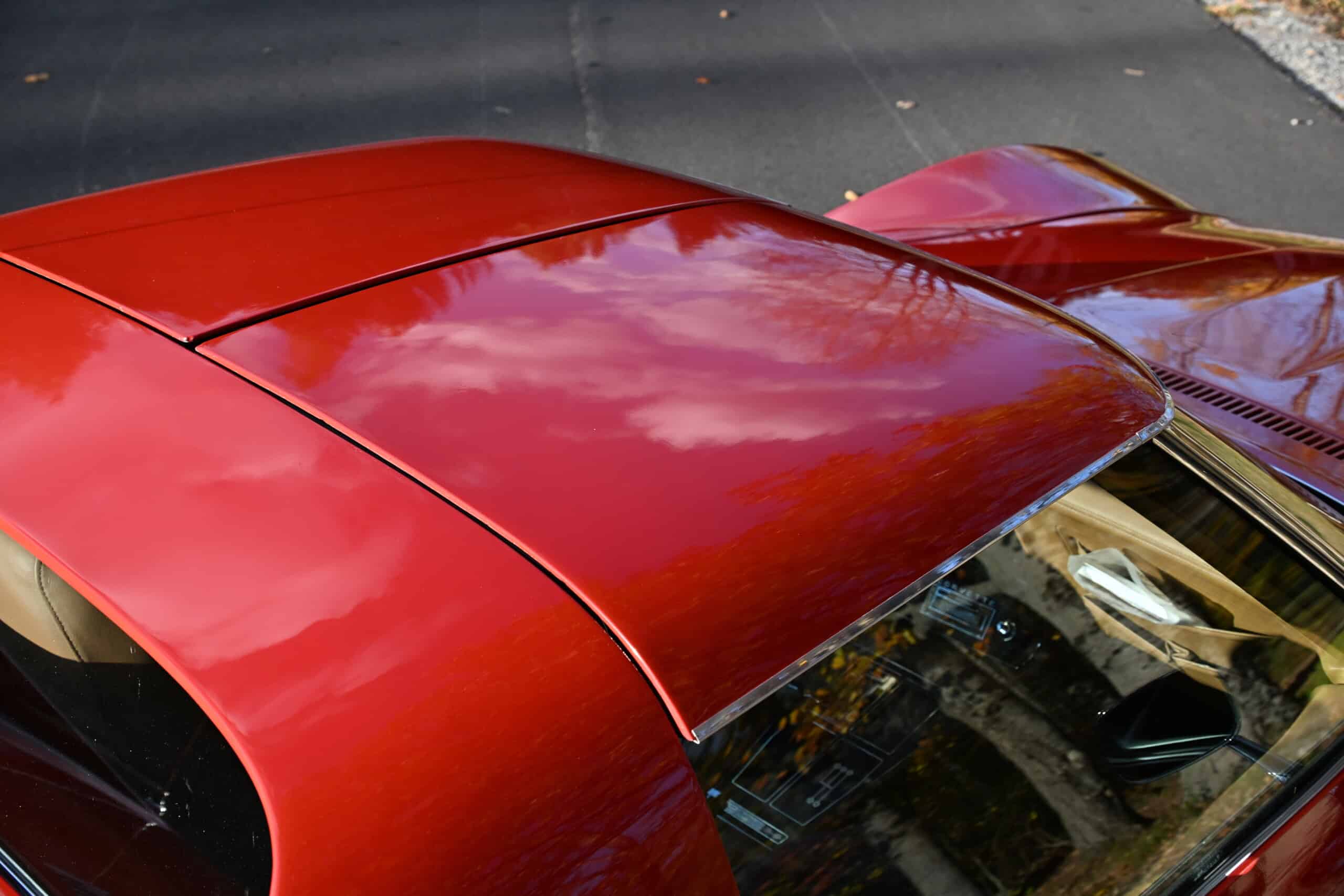 1972 Chevrolet corvette — Close-up of red classic car roof and windshield with reflections.