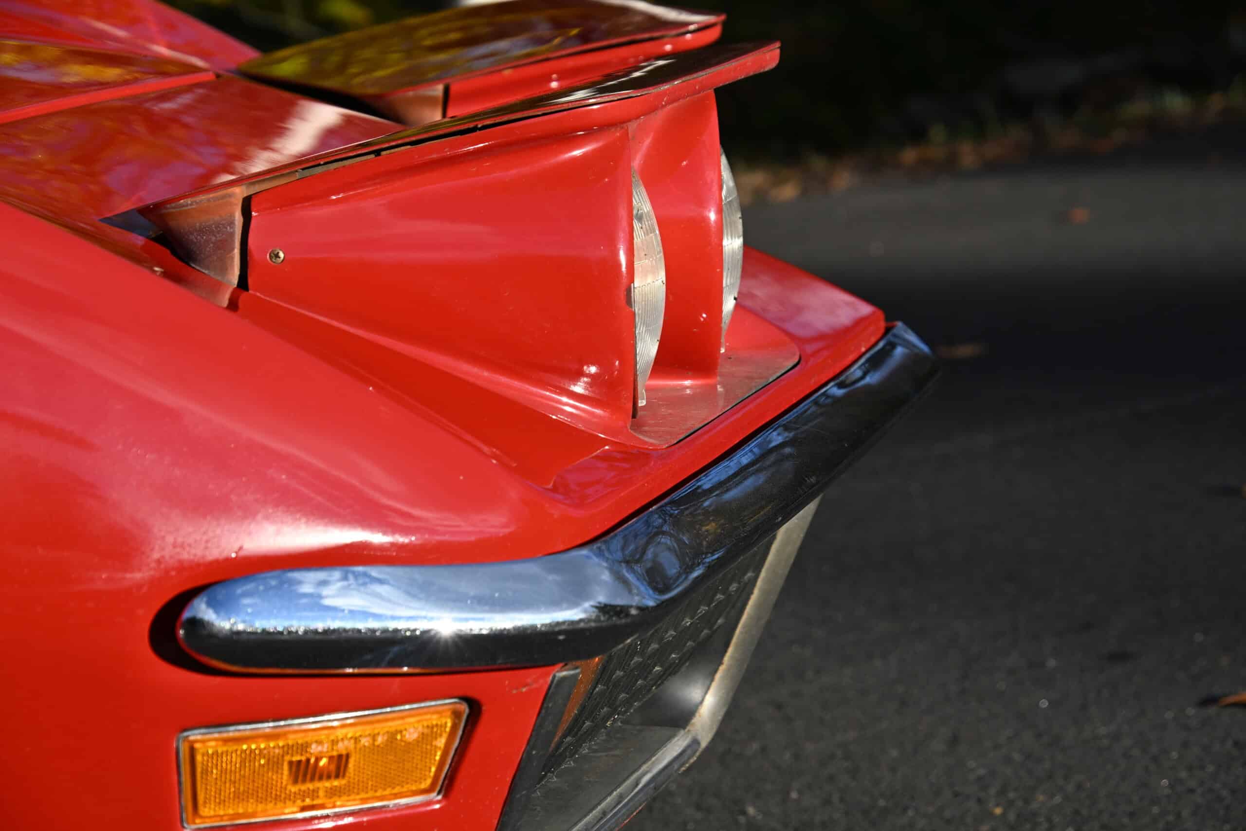 1972 Chevrolet corvette — Rear view of a red classic car with spoiler and chrome bumper.