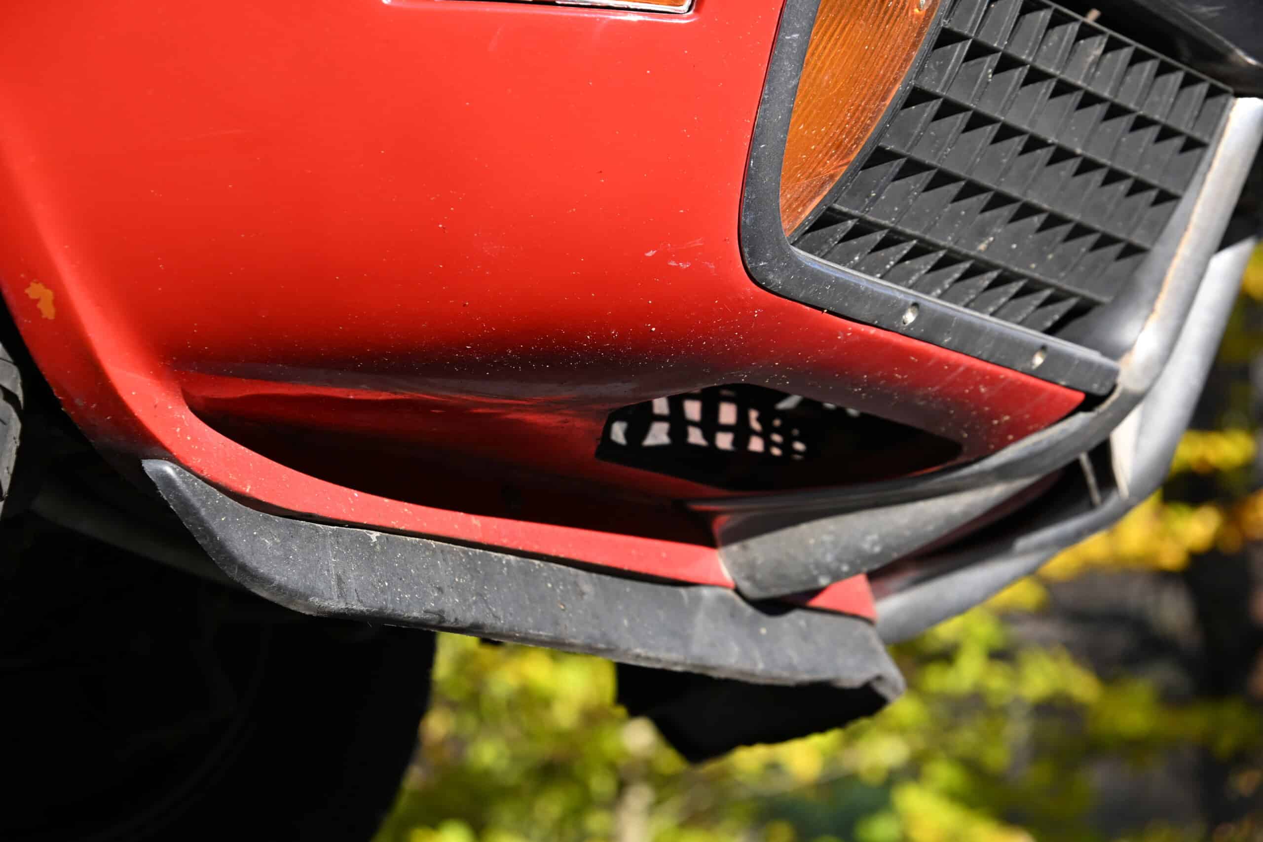 1972 Chevrolet corvette — Close-up of red classic car front bumper and grille.