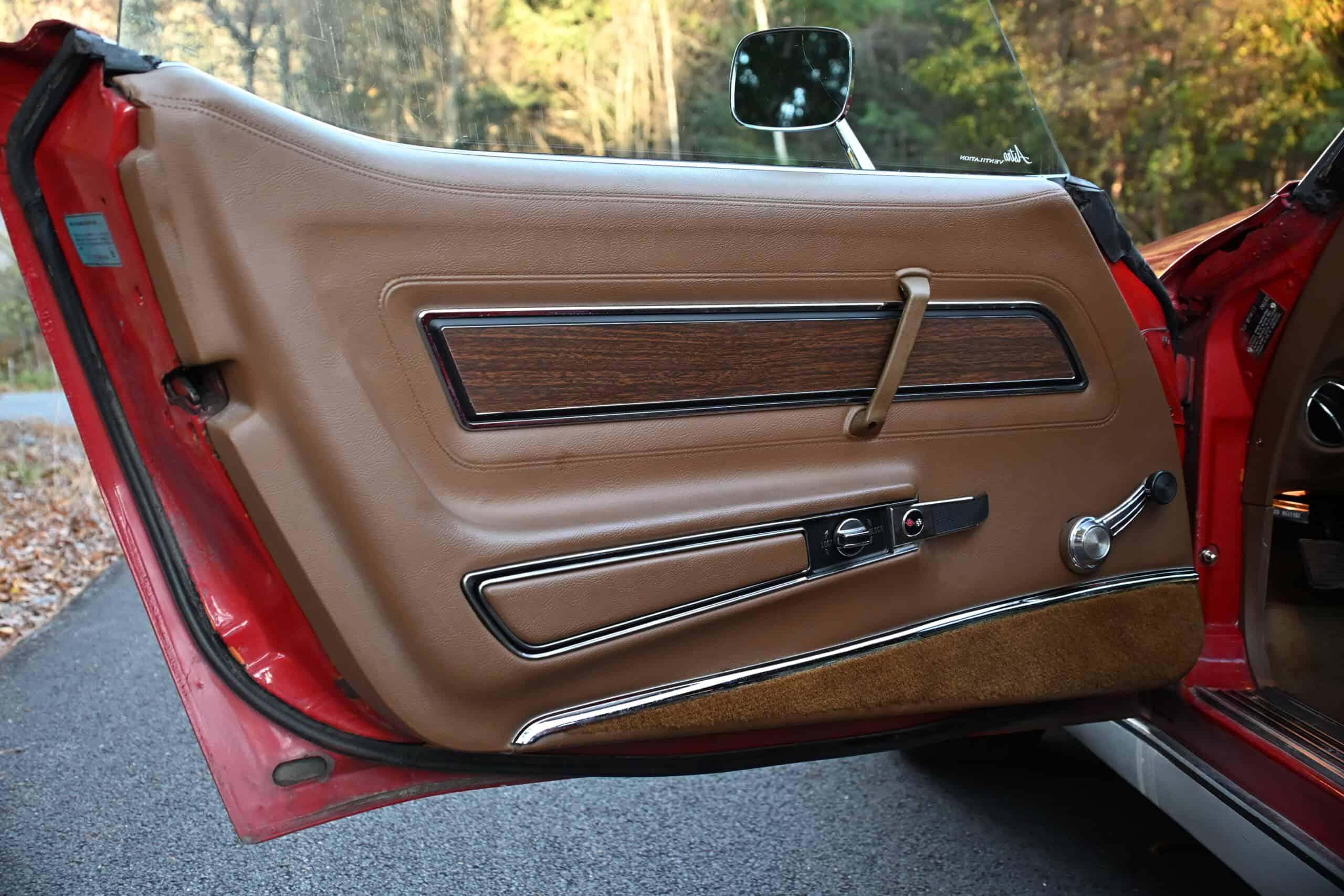 1972 Chevrolet corvette — Interior door panel of a classic car with tan upholstery and wood trim.