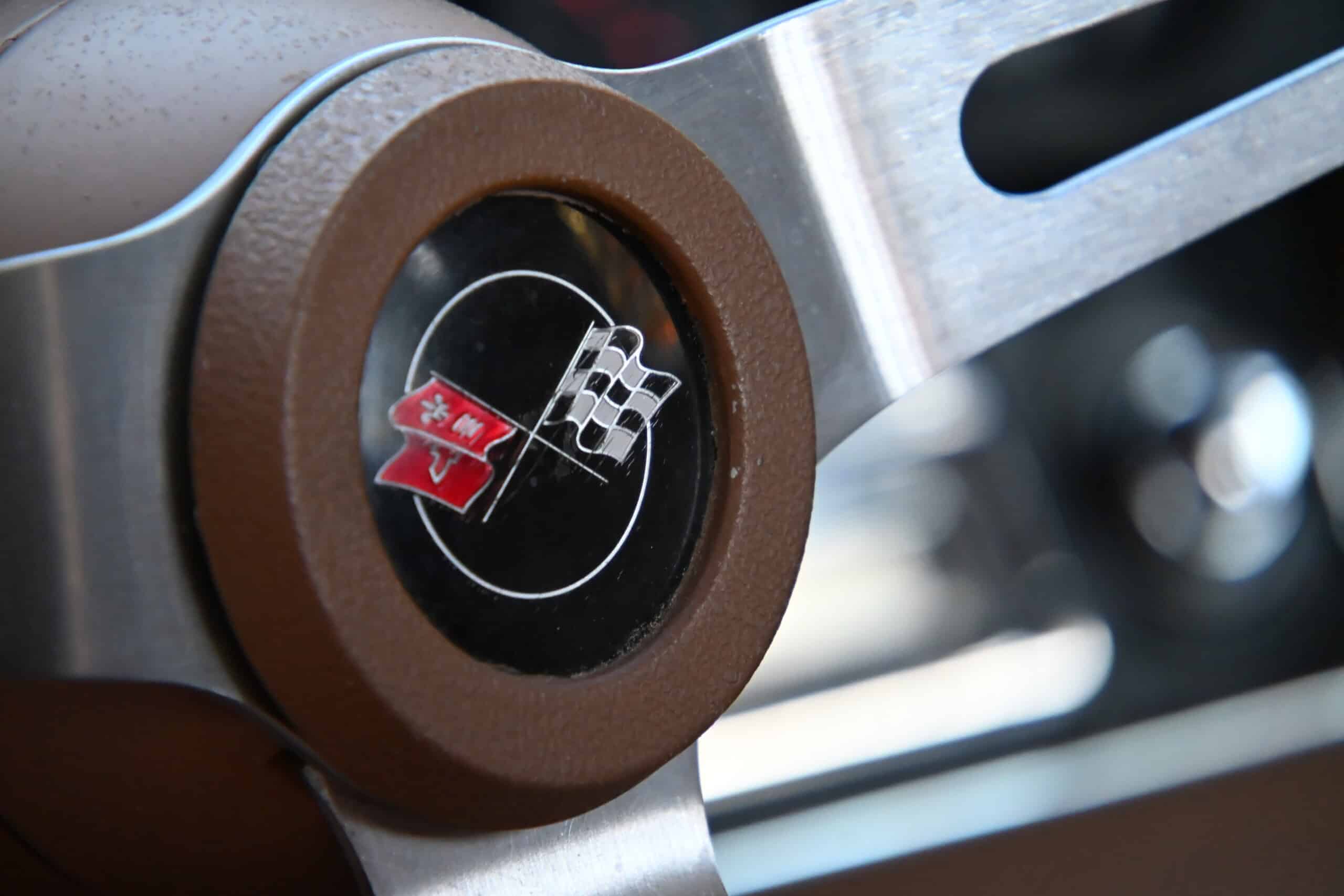 1972 Chevrolet corvette — Close-up of a classic car steering wheel with flag emblem.