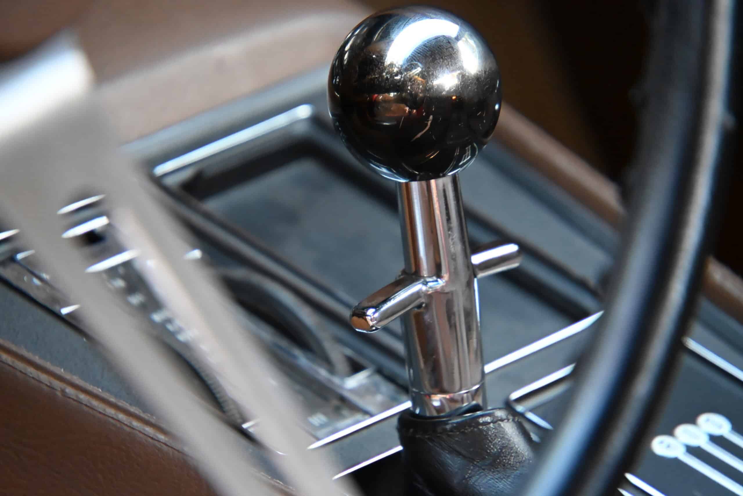 1972 Chevrolet corvette — Close-up of a classic car gear shift with black knob and chrome details.