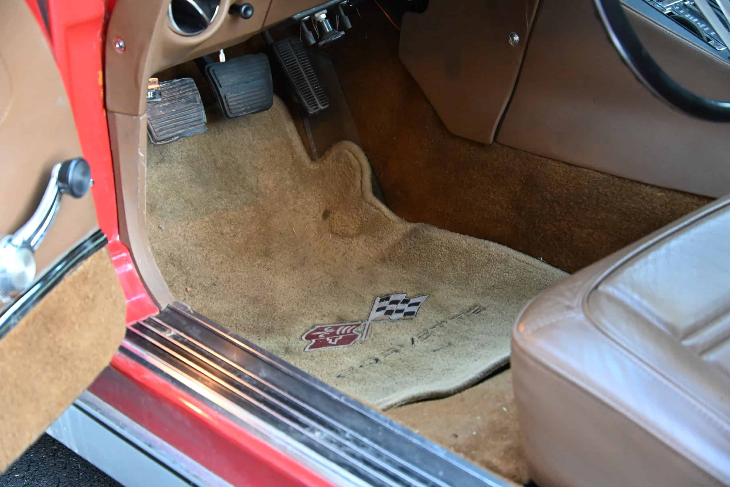 1972 Chevrolet corvette — Close-up of classic car interior showing carpet, pedals, and seat.