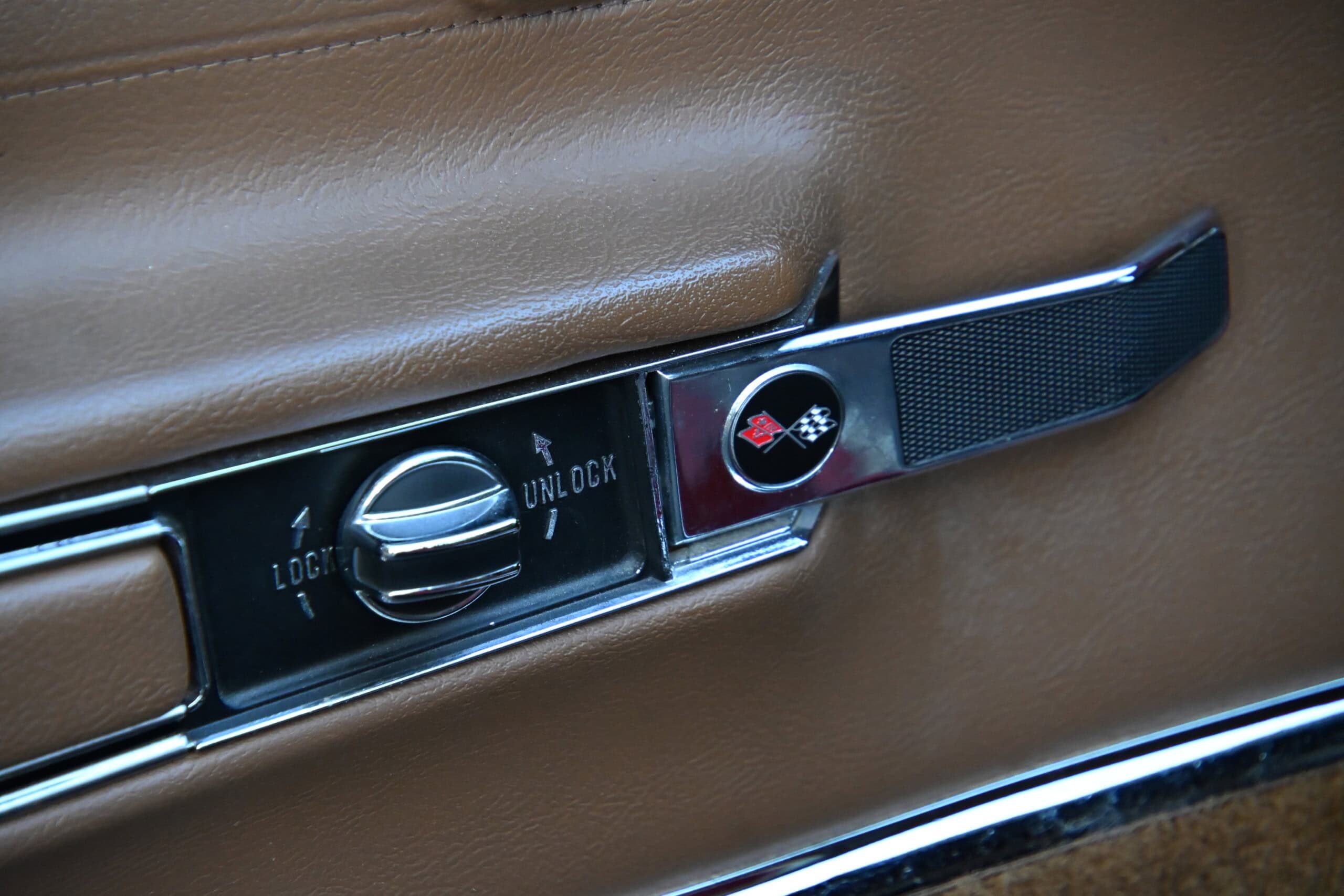 1972 Chevrolet corvette — Close-up of classic car interior door lock and handle.