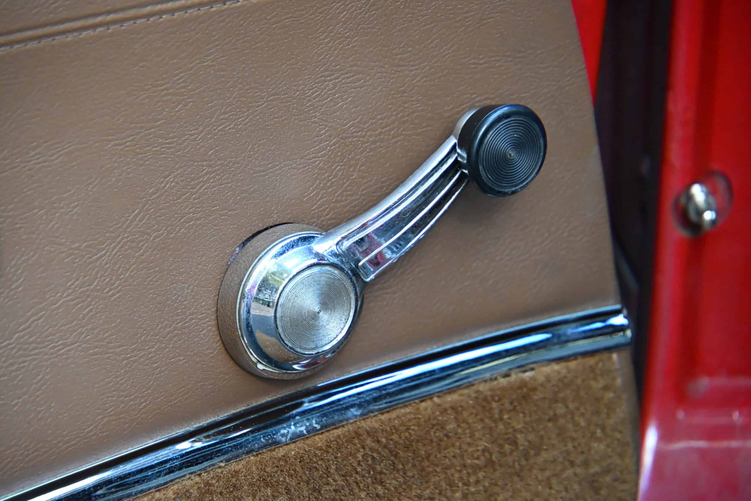 1972 Chevrolet corvette — Close-up of vintage door handle in classic car interior.