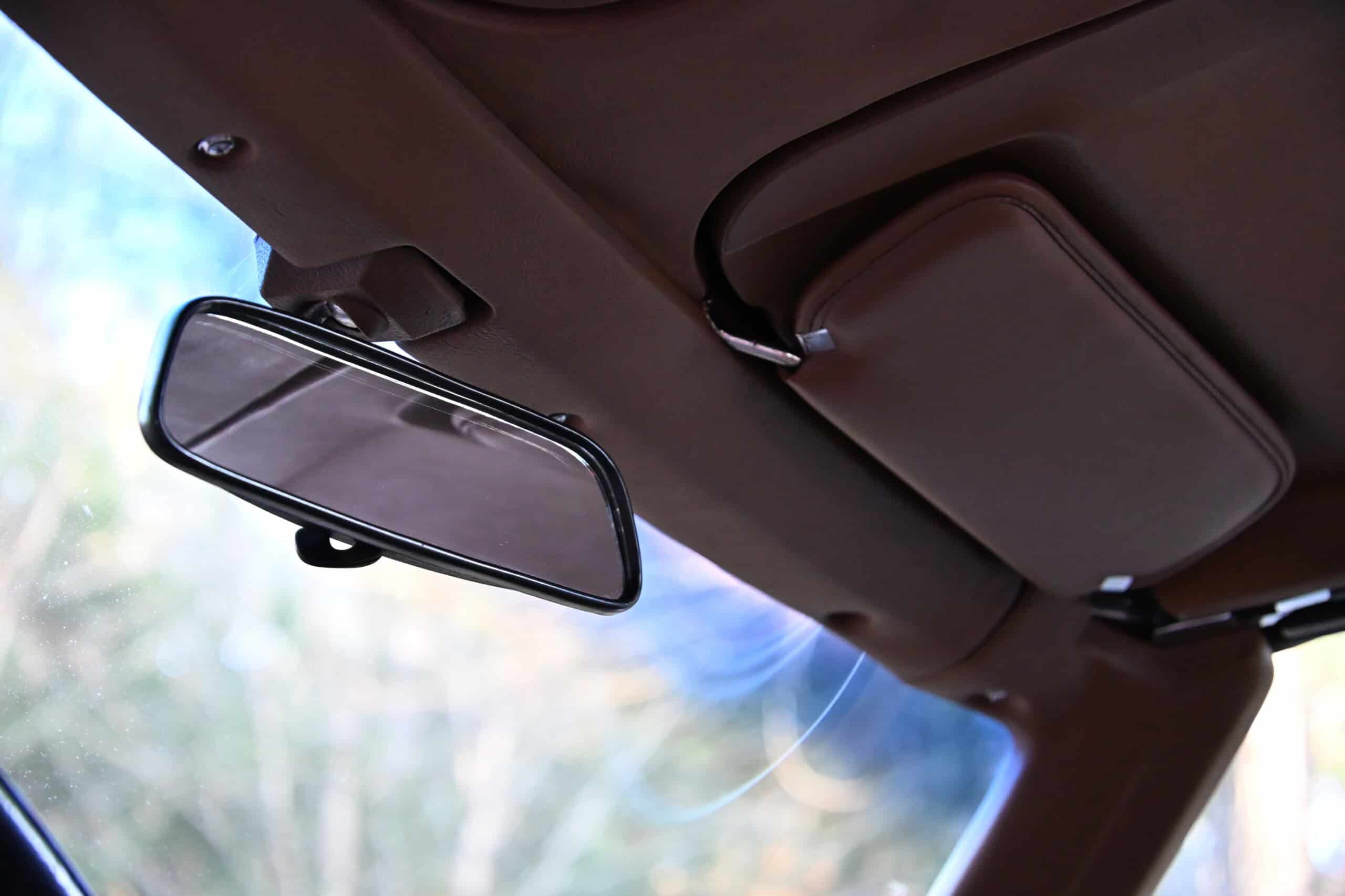 1972 Chevrolet corvette — Close-up of rearview mirror and sun visor inside classic car.