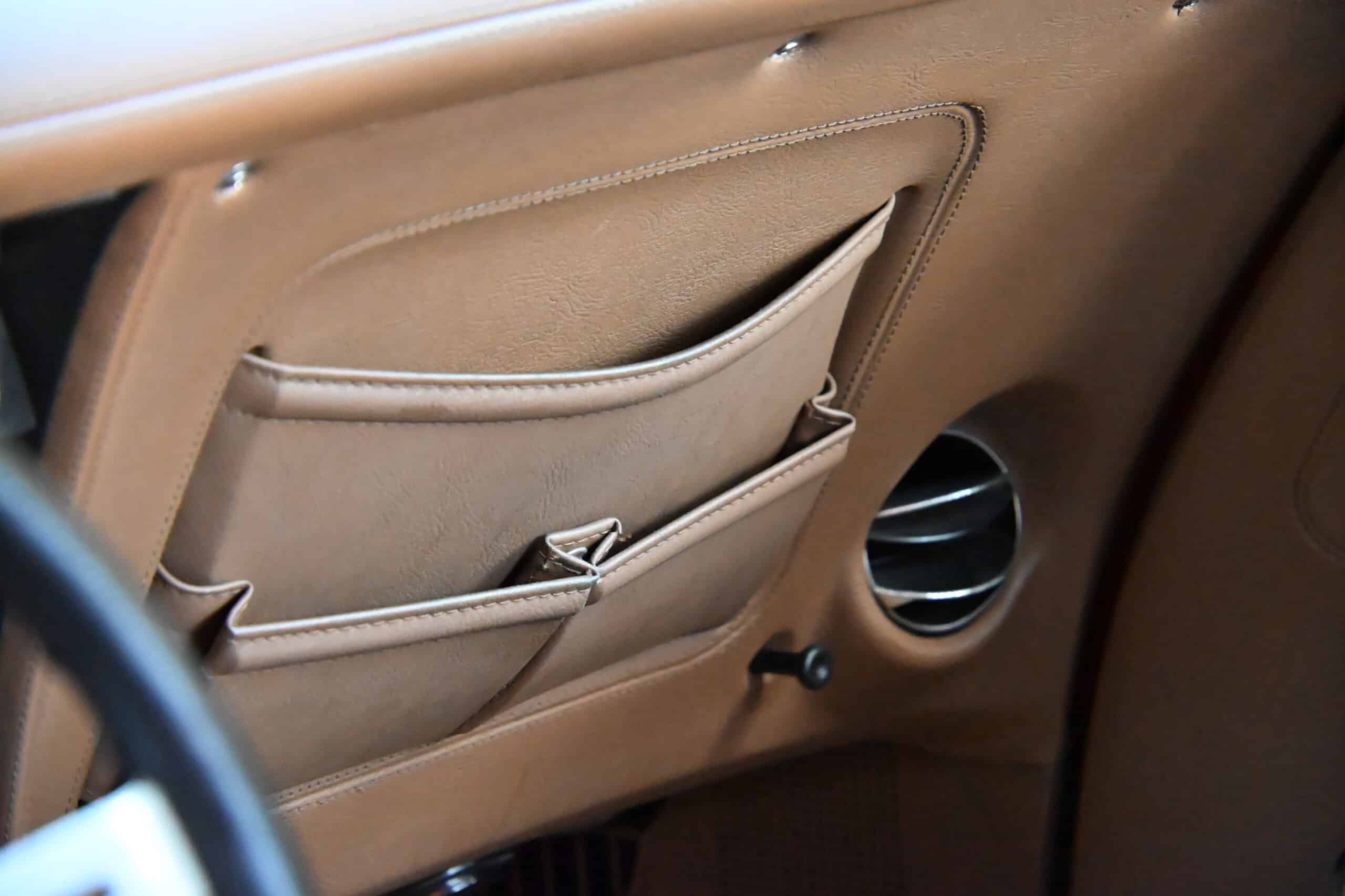 1972 Chevrolet corvette — Close-up of beige interior door panel with storage pocket and speaker.