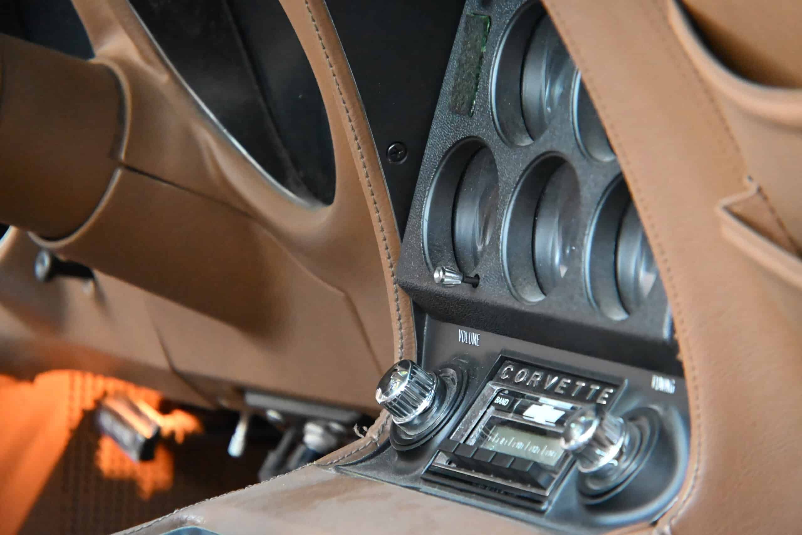 1972 Chevrolet corvette — Close-up of classic car interior dashboard with gauges and radio.