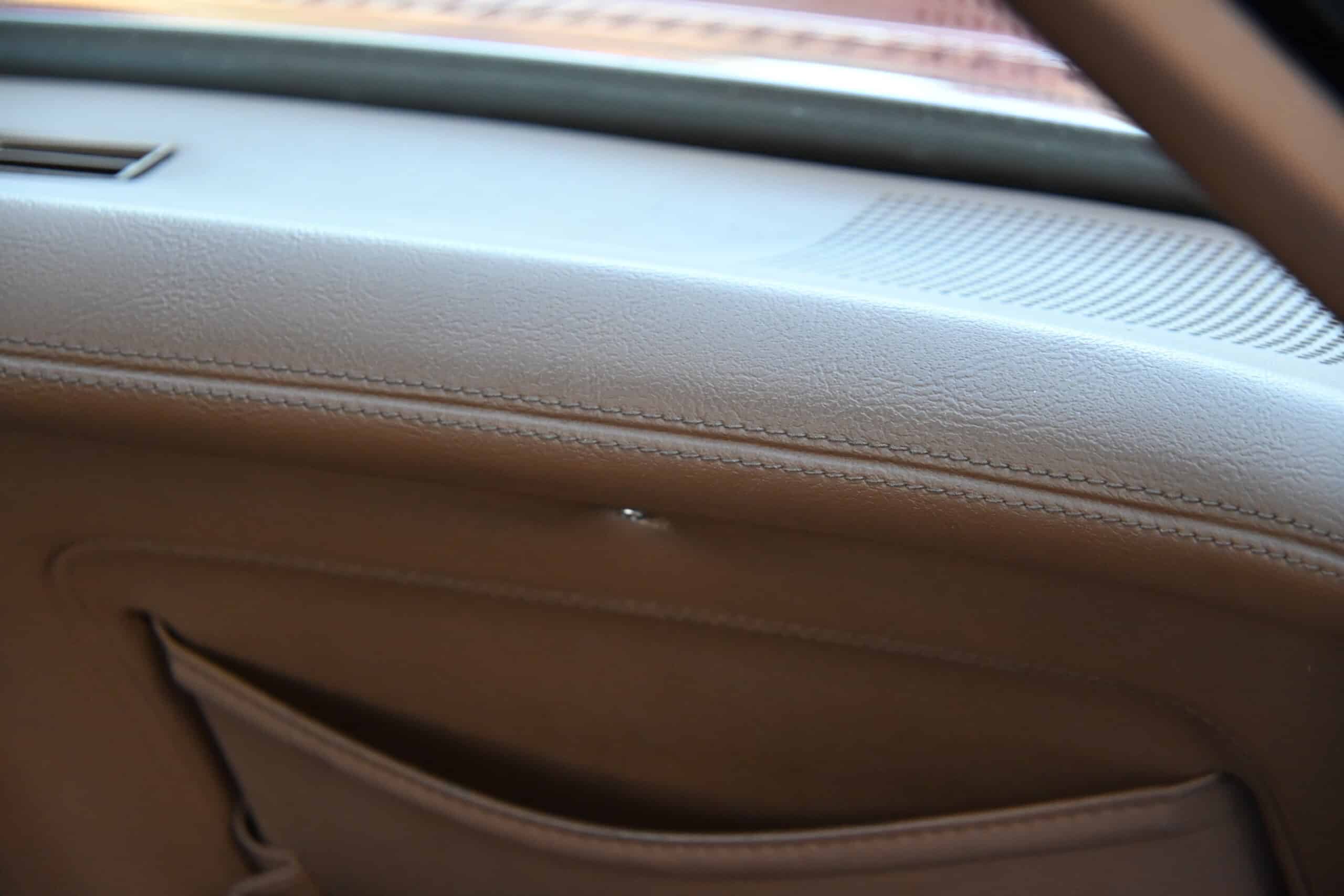 1972 Chevrolet corvette — Close-up of classic car interior door panel with leather finish.