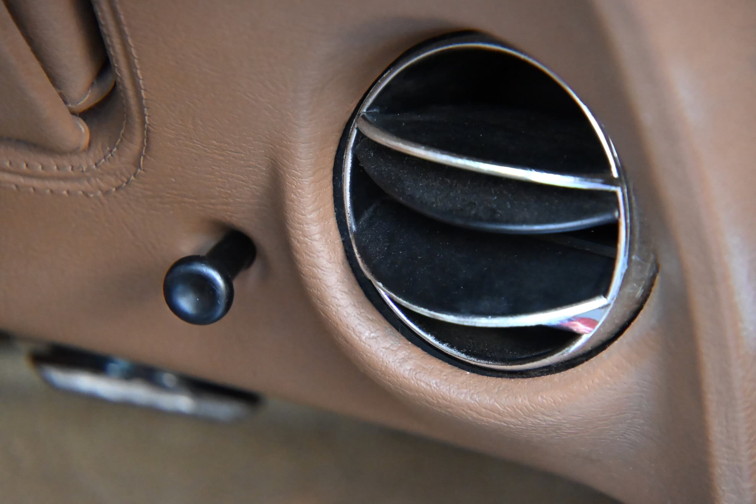 1972 Chevrolet corvette — Close-up of classic car interior air vent with brown dashboard.