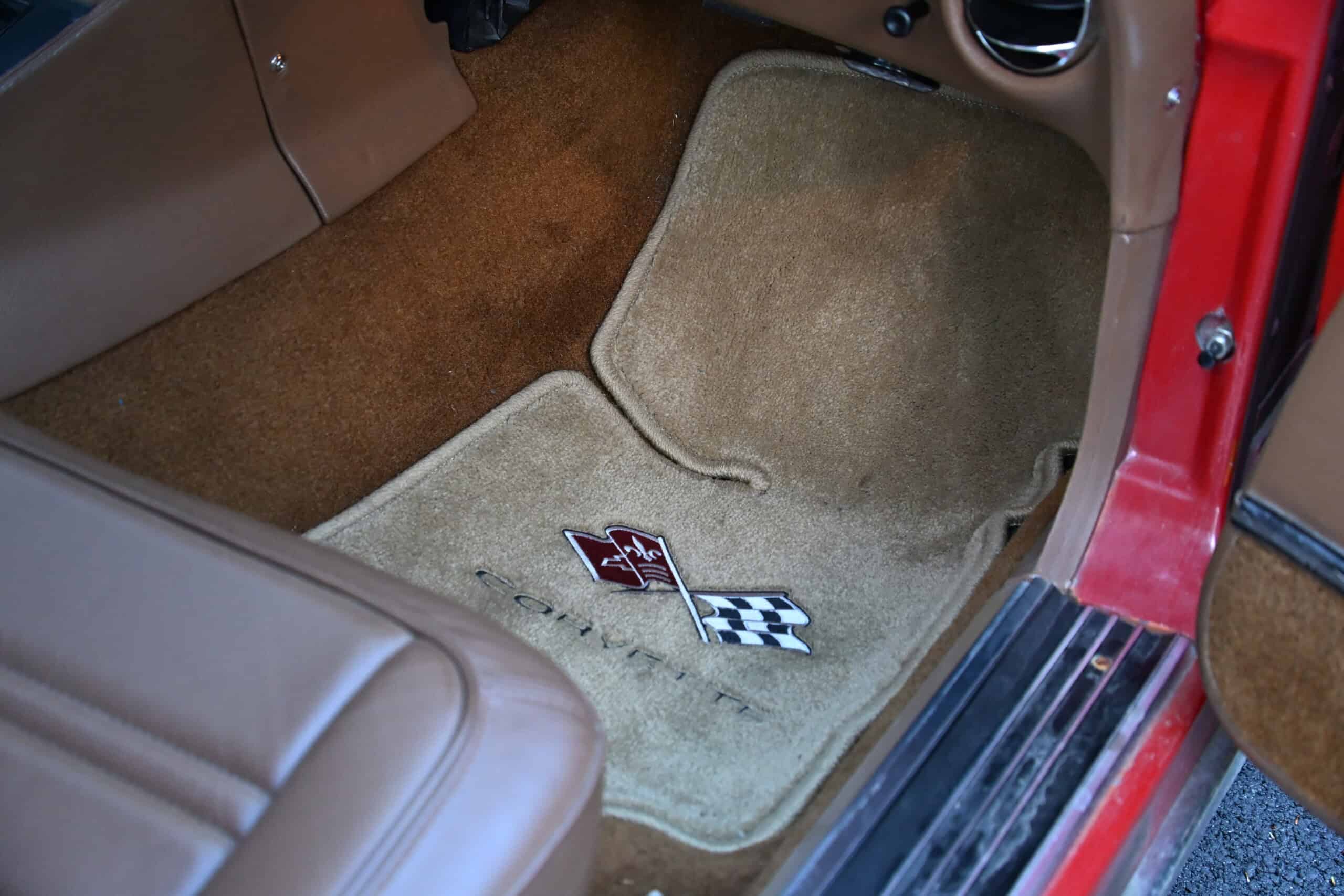 1972 Chevrolet corvette — Close-up of beige carpeted floor mat in classic car interior.