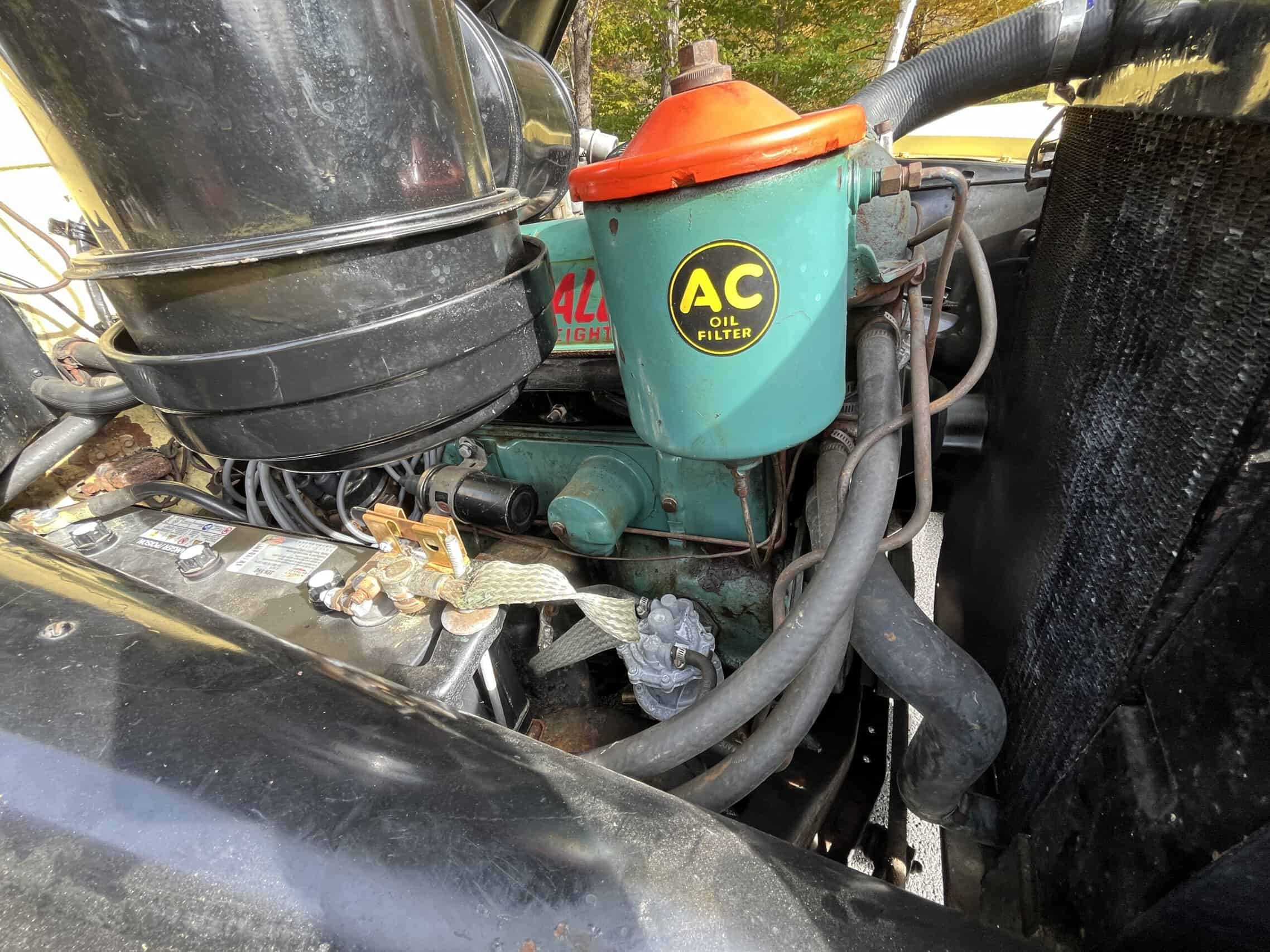 1953 Buick special — Close-up of engine with oil filter and hoses in a classic car.