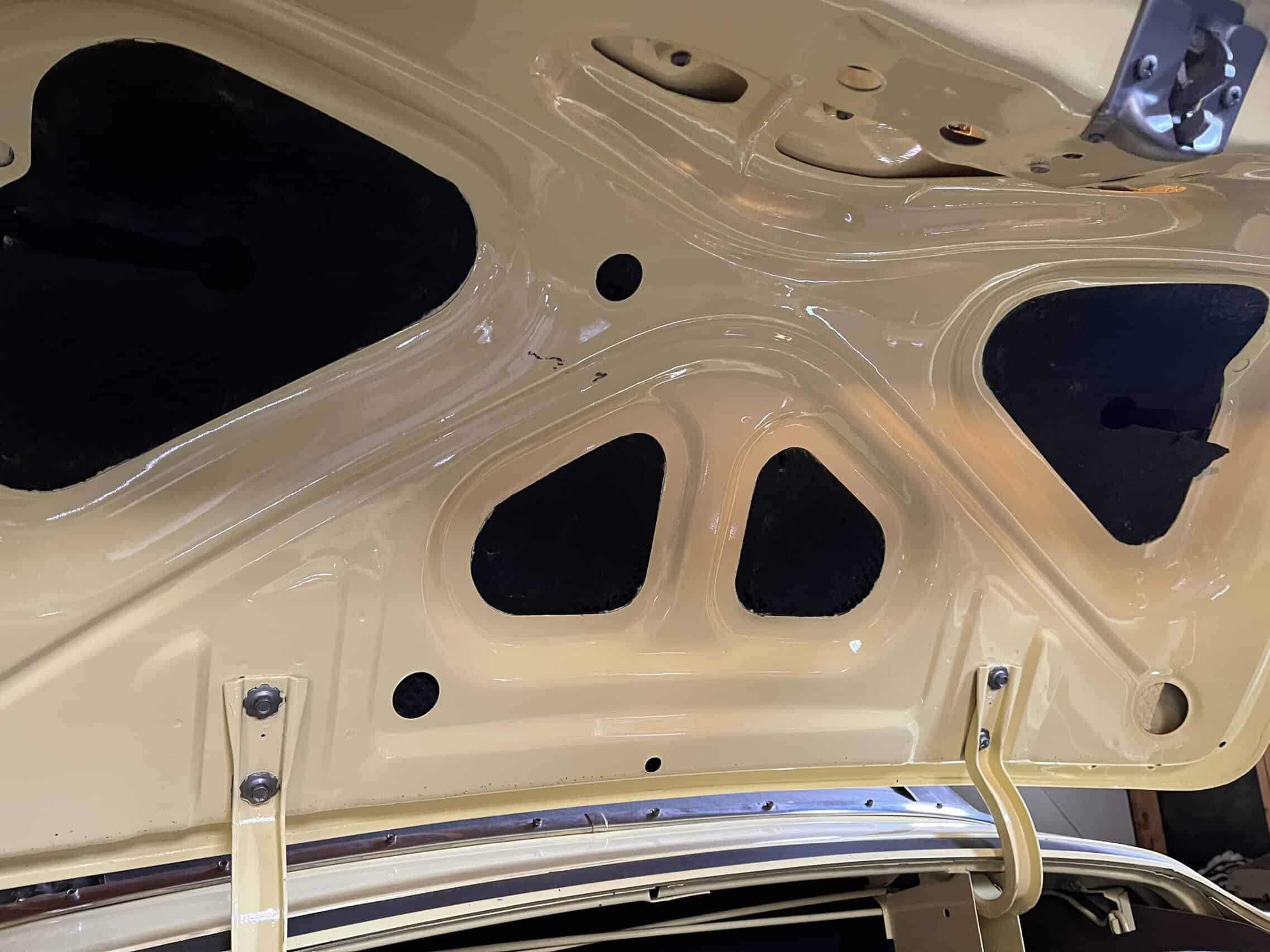1953 Buick special — View of the trunk interior of a classic car with beige paint and black padding.