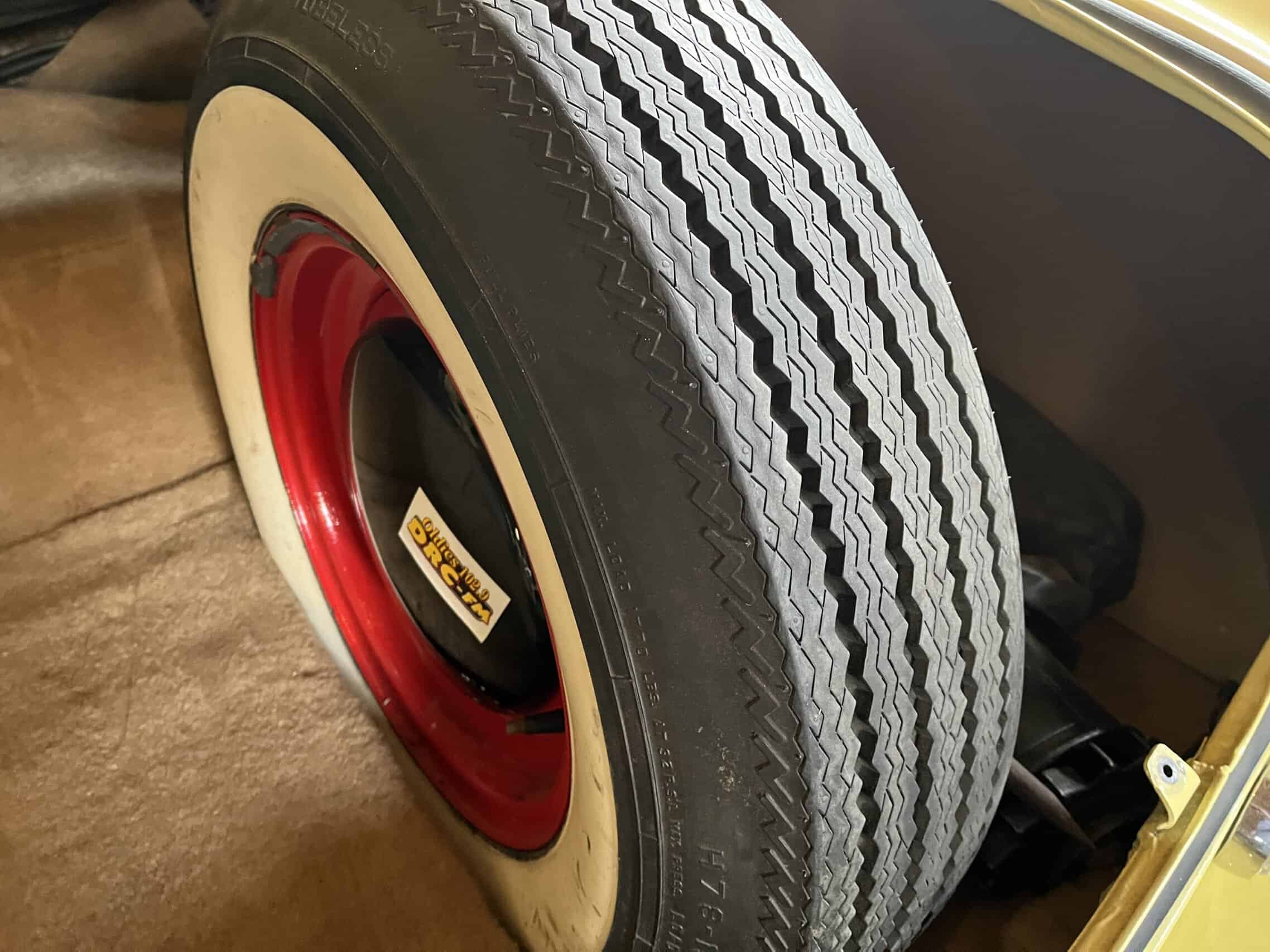 1953 Buick special — Close-up of a classic car tire with whitewall and red rim.