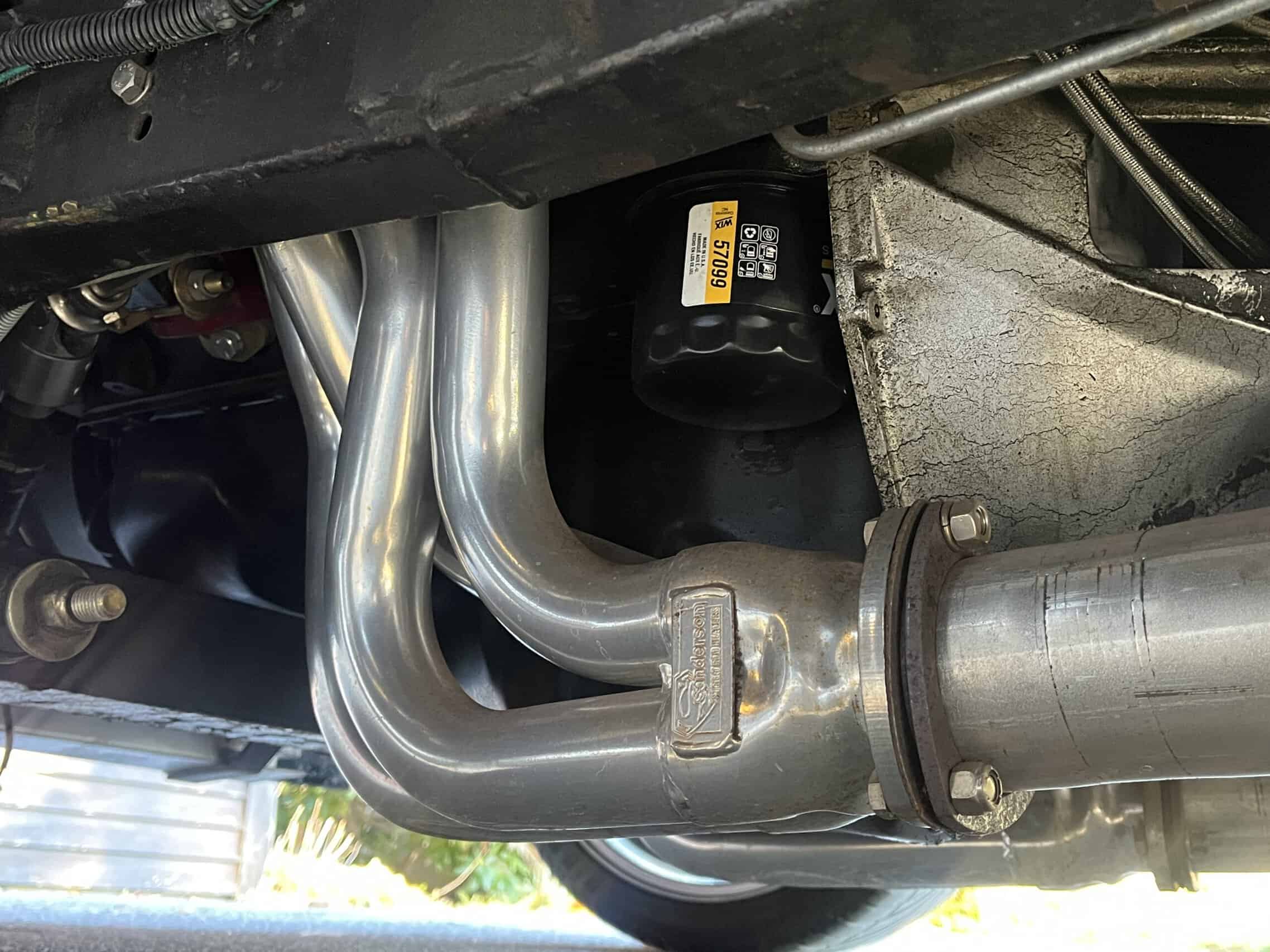 1941 Willys Custom Street Rod — Close-up of exhaust pipes and engine components in a classic car.